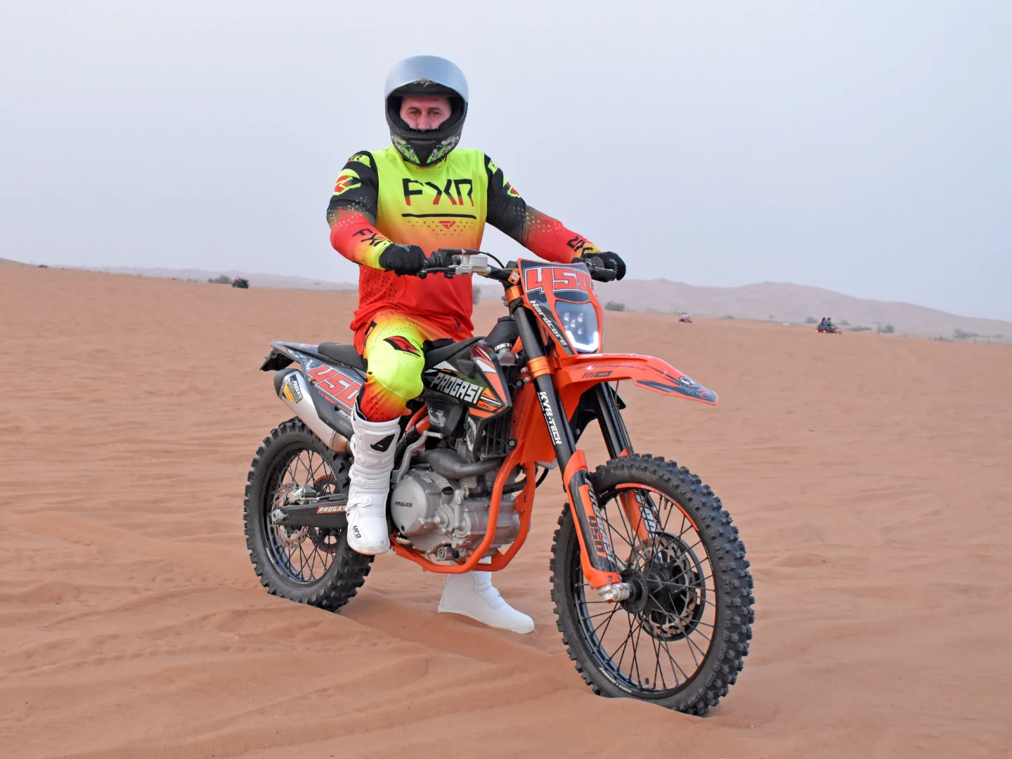 Safety gears while driving a dune buggy in red sand desert Dubai