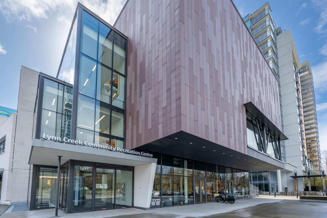 Exterior real estate photography of the Lynn Creek Community Recreation Centre, highlighting the modern architectural design and the high-quality public amenities available to residents in the immediate neighborhood.