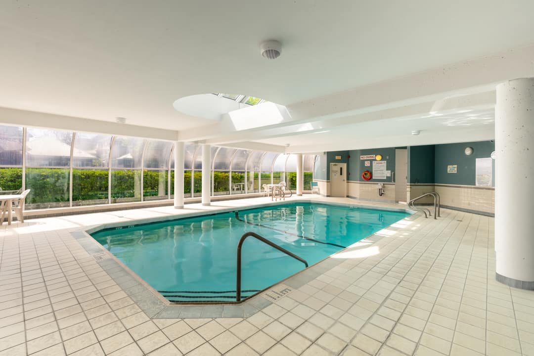 Building amenity featuring a heated indoor pool under a domed glass atrium, a key selling point for year-round use.