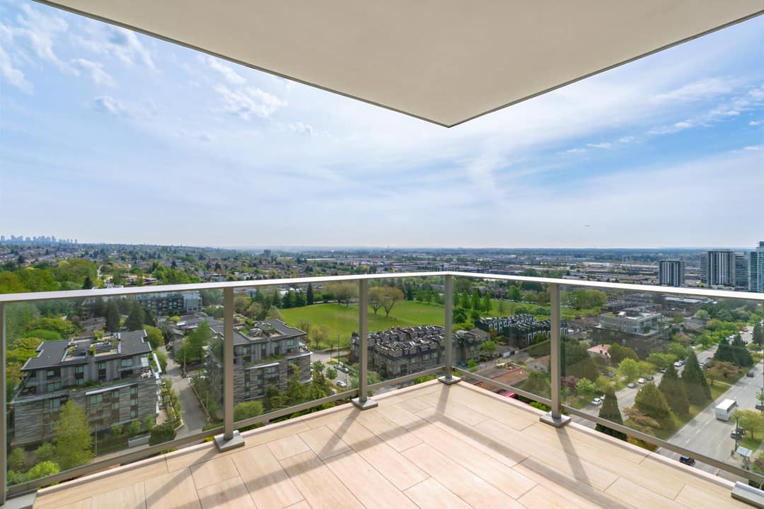 Spacious balcony at Cambie Gardens with glass railings and an unobstructed panoramic view of Vancouver's Cambie corridor, parks, and surrounding neighbourhoods.