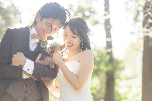 森の中で愛犬と一緒に微笑むカップル