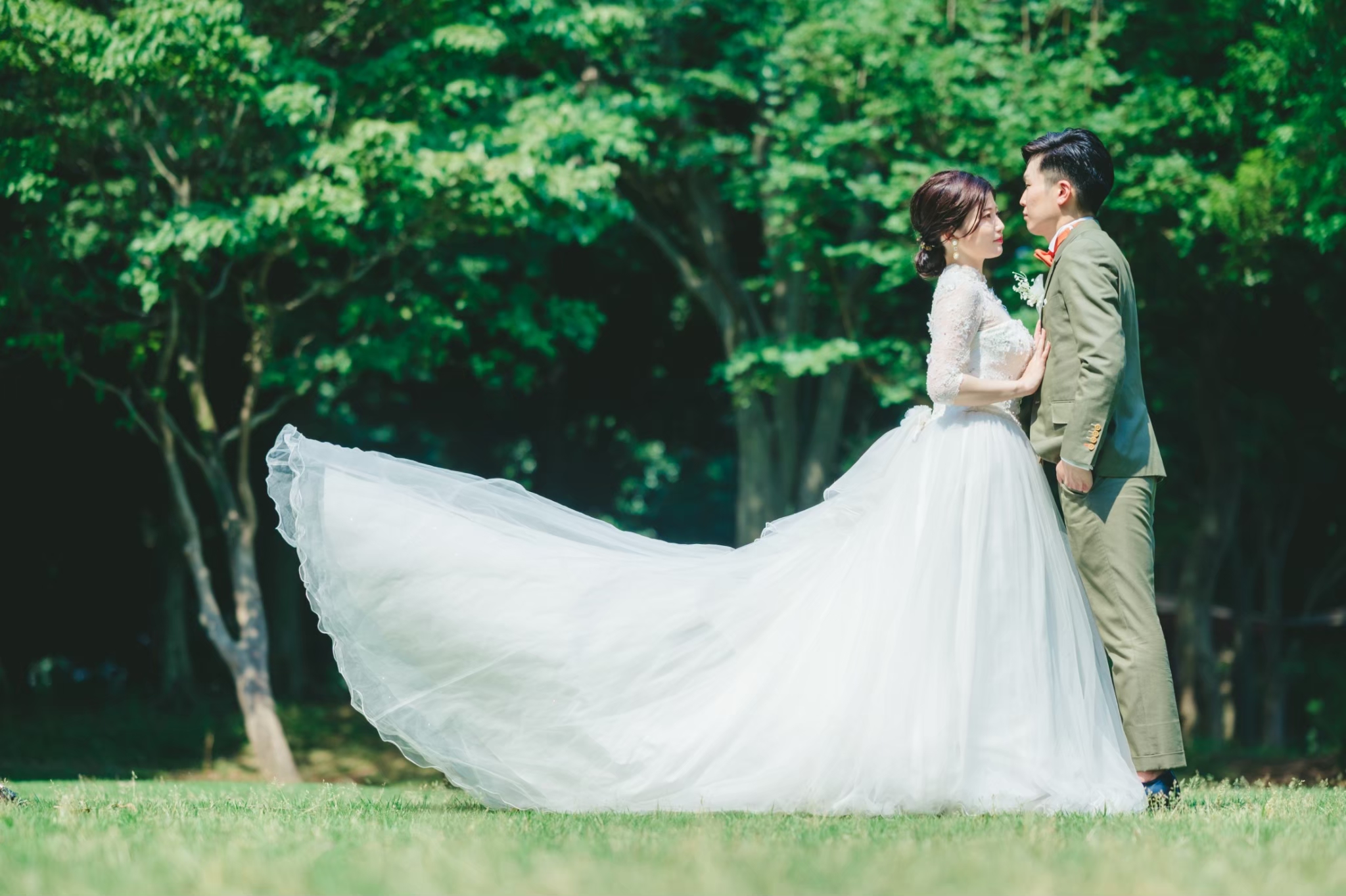 屋外のグリーンの中で寄り添う新郎新婦
