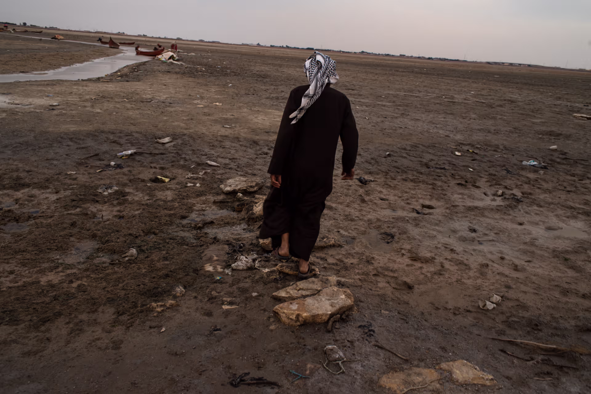 Photo 10 –Al Khor, Iraq. Mahdi Mutir is a father of five and used to be a fisherman in Basra.&nbsp;<b>Since 2021, the local marshes have been completely dry. He attributes this to the new water station by an oil company. Mutir’s boat is stuck in the mud and he remains deprived of his livelihood.</b>