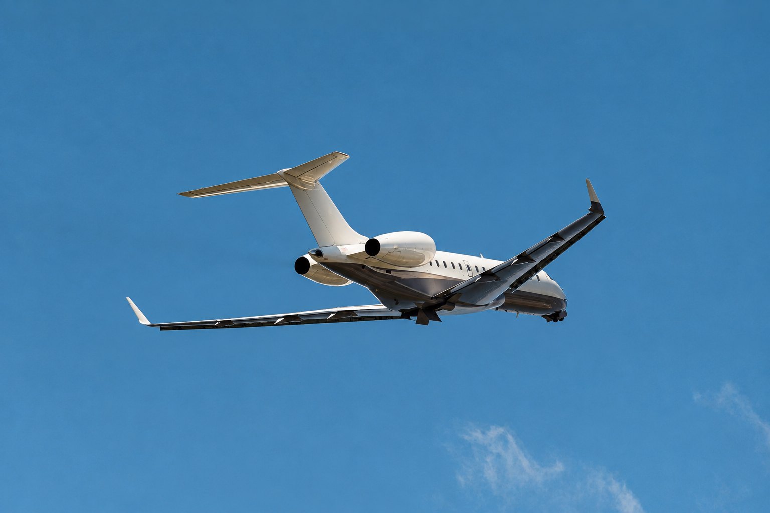 Black-and-white photograph of two different-sized business jets, a light jet and a large-cabin aircraft, parked side by