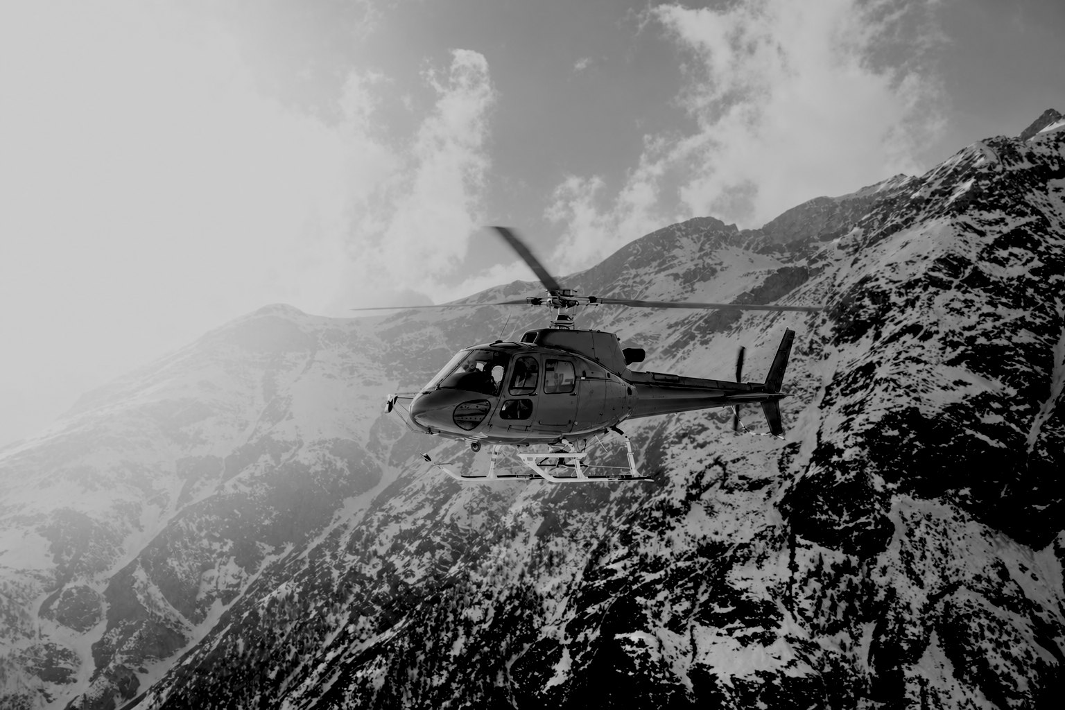 Helicopter flying over snowy mountains