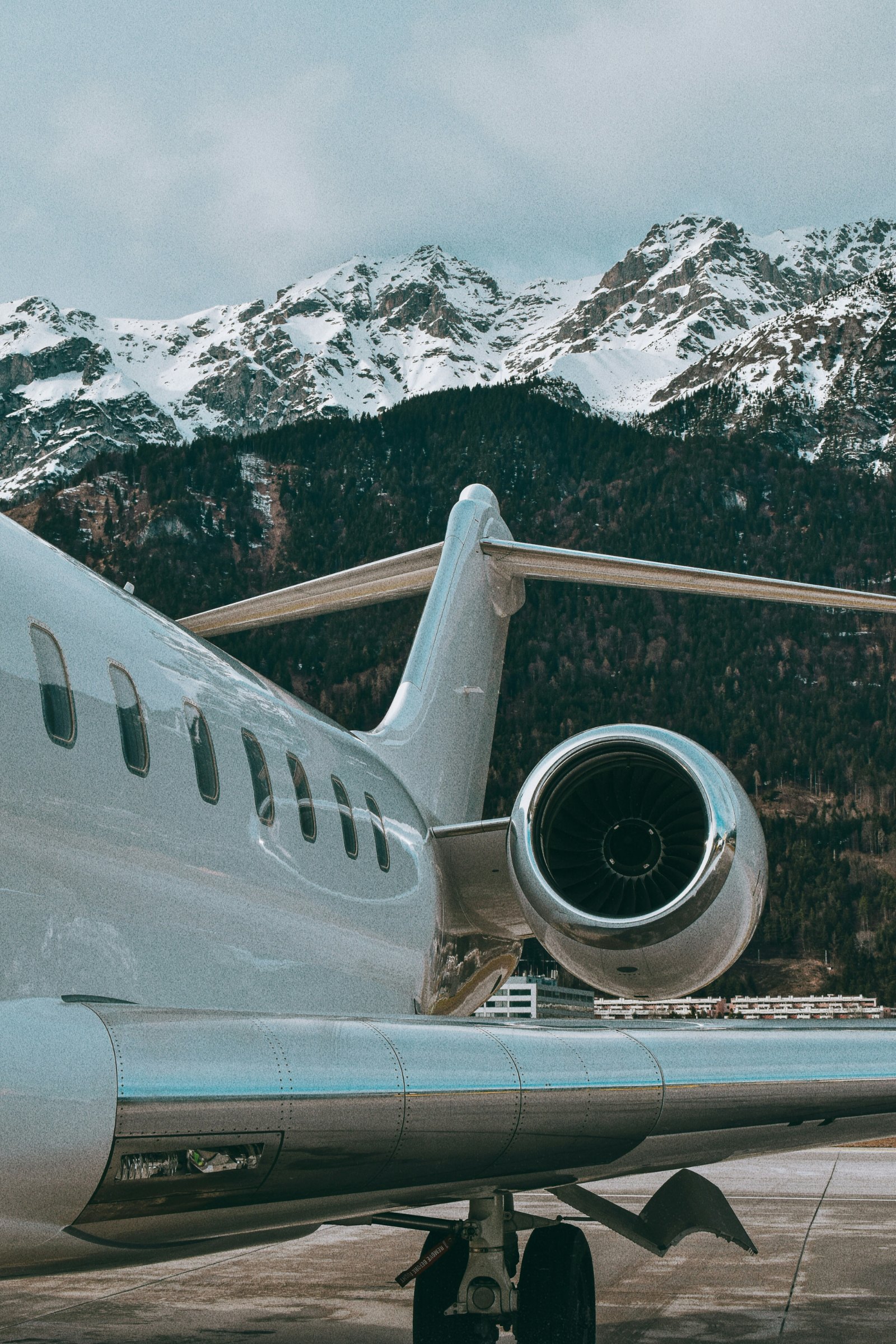 Business jet parked beneath snow-capped mountains