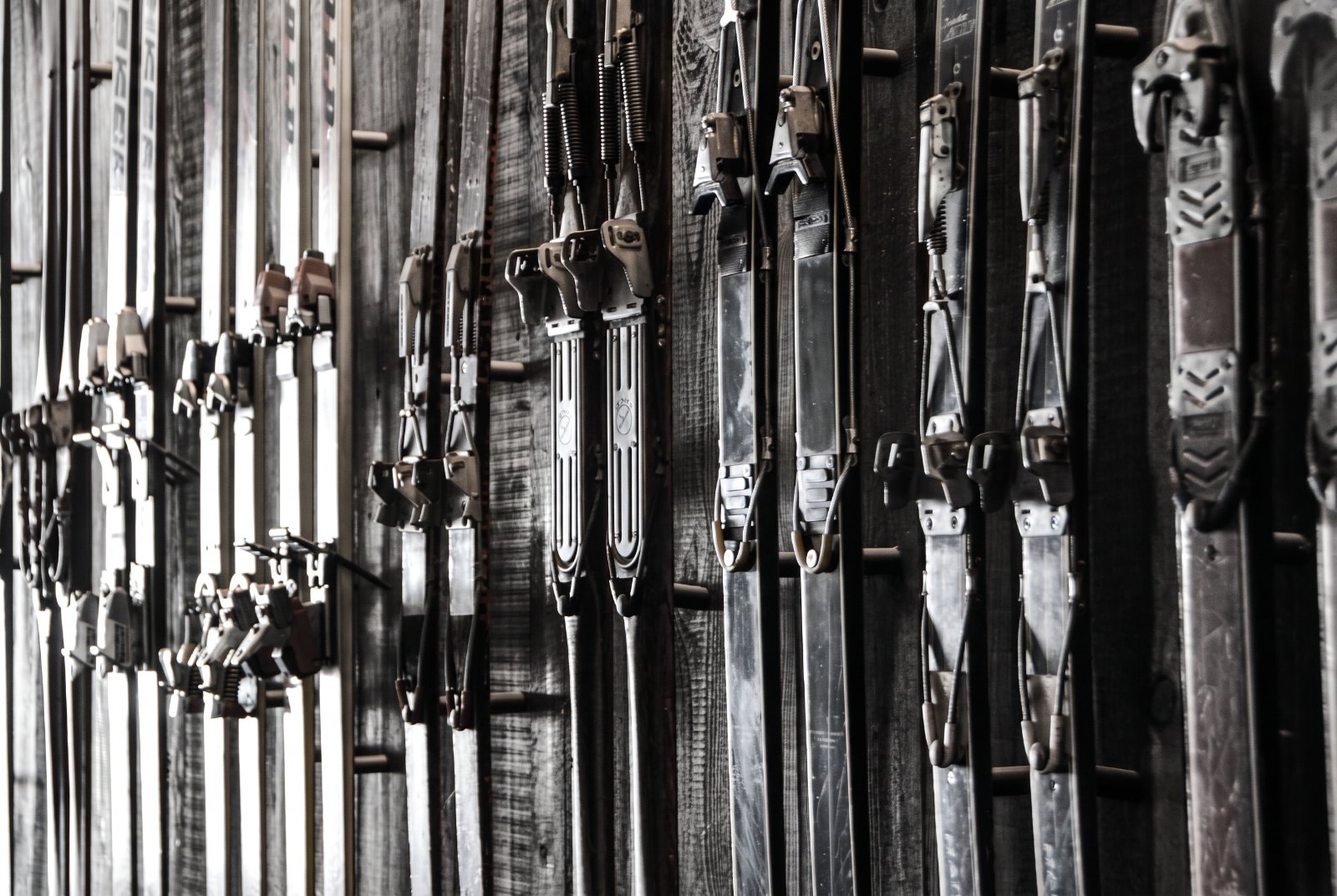Understated black-and-white image of ski equipment and luggage being loaded into the hold of a large-cabin business jet