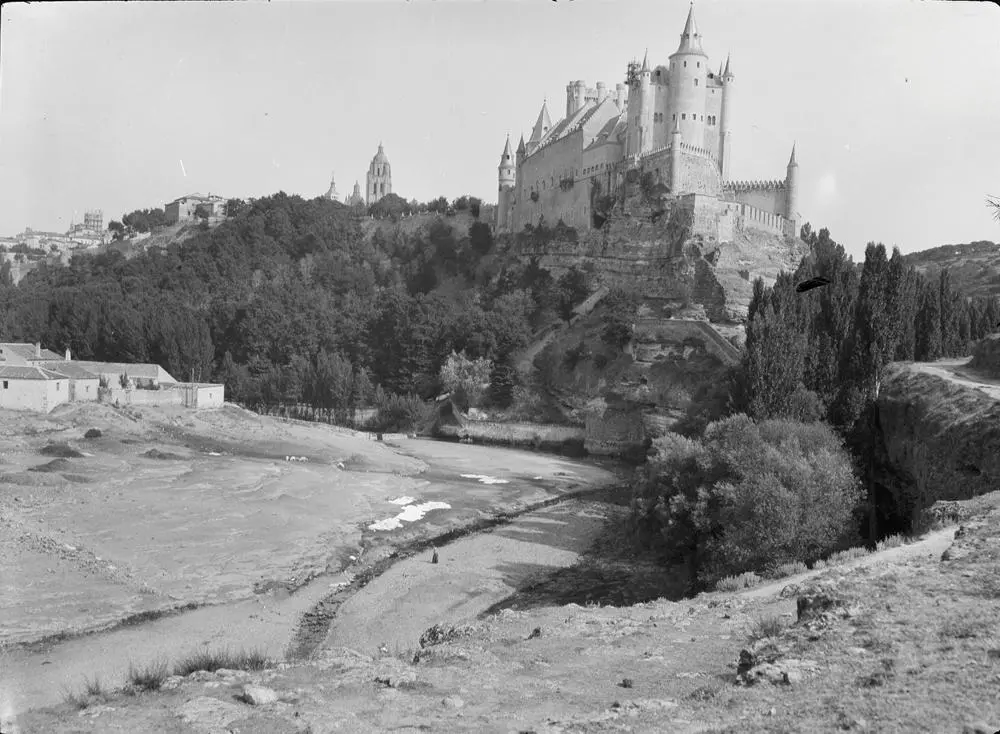 Alcázar & Segovia gegenüber [Alcázar y Segovia al frente. Vista de la fortaleza con la ciudad tras ella y solar en primer plano].