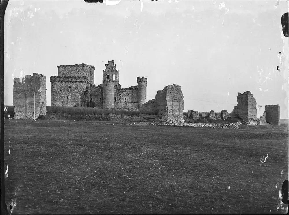 Castillo de Turégano [Ruinas del castillo del que se conservan algunas torres y el campanario de la iglesia integrada en su construcción. Postes de cableado eléctrico alrededor].