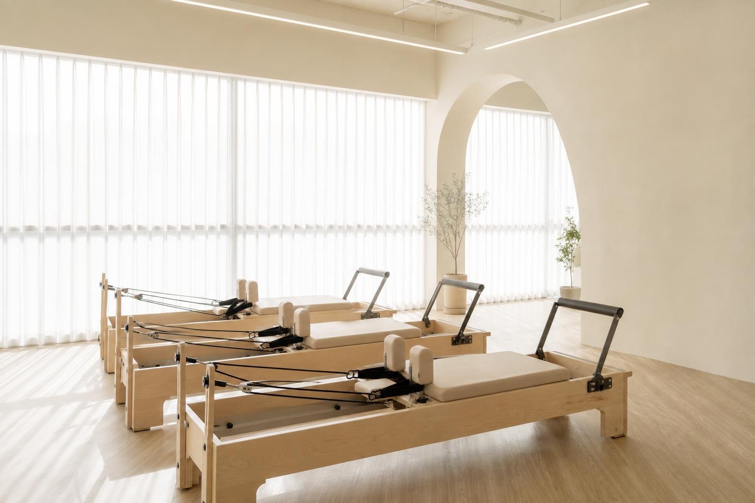 A minimalist Pilates studio bathed in natural light with a reformer