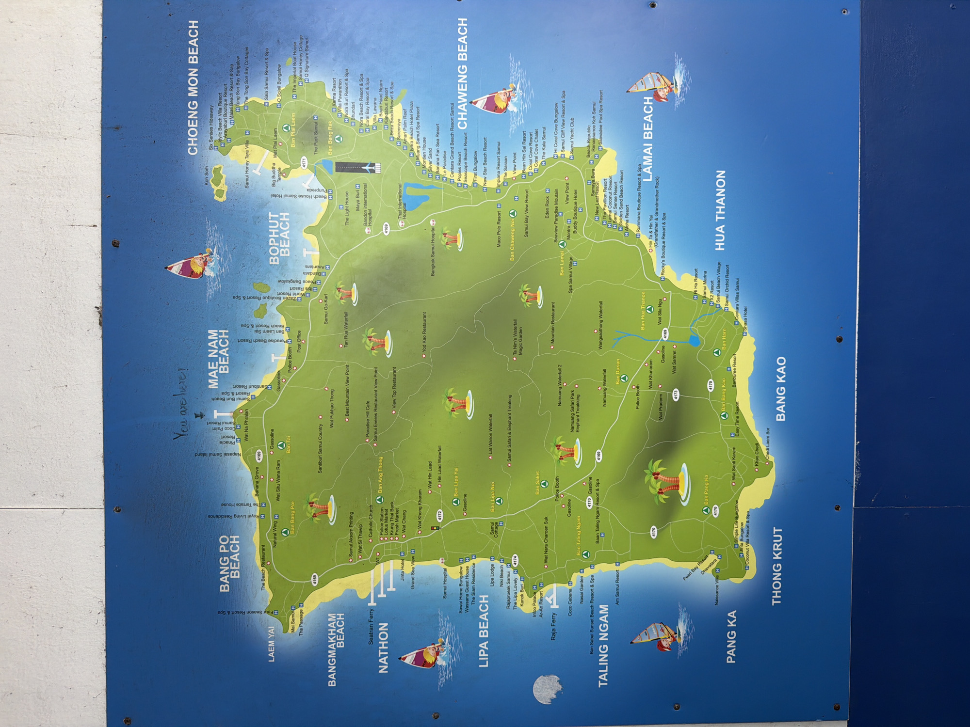 This is a map of the island of Ko Samui, Thailand. It displays various beaches, resorts, hotels, and landmarks, including temples, waterfalls, and viewpoints. The map also features major roads and points of interest like hospitals and airports. The handwritten note indicates the location "You are here!" is near Mae Nam Beach.