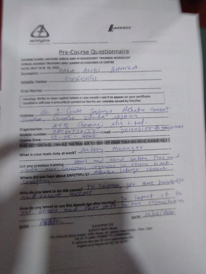 The image is a pre-course questionnaire for a "Unleash Minds and Management Training Workshop" held at the "Training and Learning Conference Centre" in Ashaka, Nigeria. The questionnaire is filled out by someone named Bola Afeli Hamza, who works as a Safety Manager for AYB Gerensi plus Ltd. Their mobile number is 08067739127. The course date is 15-05-2023. The individual states their primary duty is "safety," and their previous training involved "heart and mind safety plus and company organize in season time, other our company lectures, contract." They learned about the course in Ashaka. Their reason for taking the course is to "improve, get more knowledge and ensure success." They plan to use their knowledge after the course to "impact it to our organization."