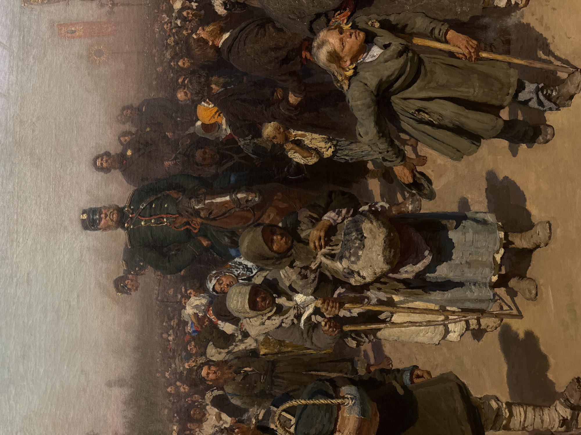 The image is a painting depicting a large, crowded scene. Predominantly, the painting features numerous people, mostly appearing as impoverished and perhaps displaced, moving through what looks like a city street. Several individuals are carrying burdens or using walking sticks for support.
Notable is a uniformed military officer on horseback positioned prominently within the crowd, potentially representing authority or overseeing the movement.
The overall tone is somber, with the subjects seemingly engaged in a desperate journey. The environment is rendered in muted colors, suggesting a dusty or bleak setting. The crowd and the overall scene suggest a period of hardship or forced relocation.
While I cannot pinpoint the precise location within Moscow without more context, the depiction of a large crowd with a military presence would be consistent with turbulent periods of Russian history, such as wartime displacement, famine, or revolution.