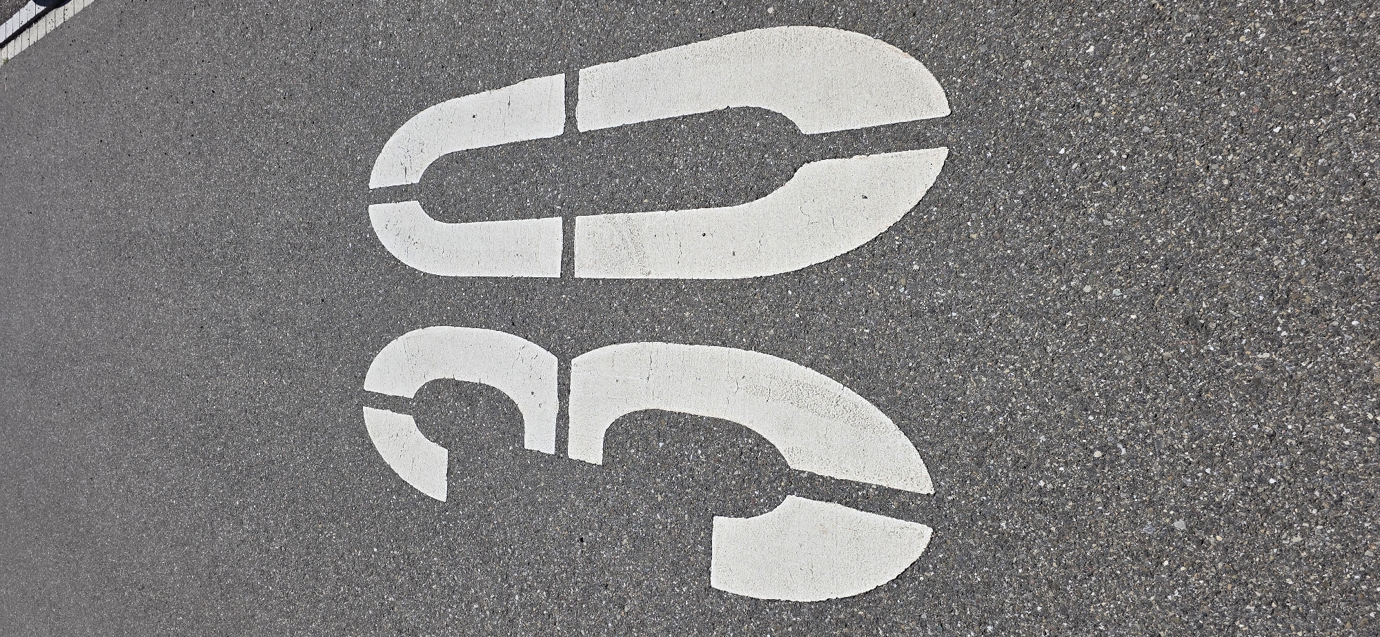 The image shows the number "30" stenciled in white paint on an asphalt road surface. The road is dark gray with visible aggregate. The "30" is a speed limit marking. The context of Lieli, Switzerland is not discernible from the image itself; it is solely based on the provided prompt.