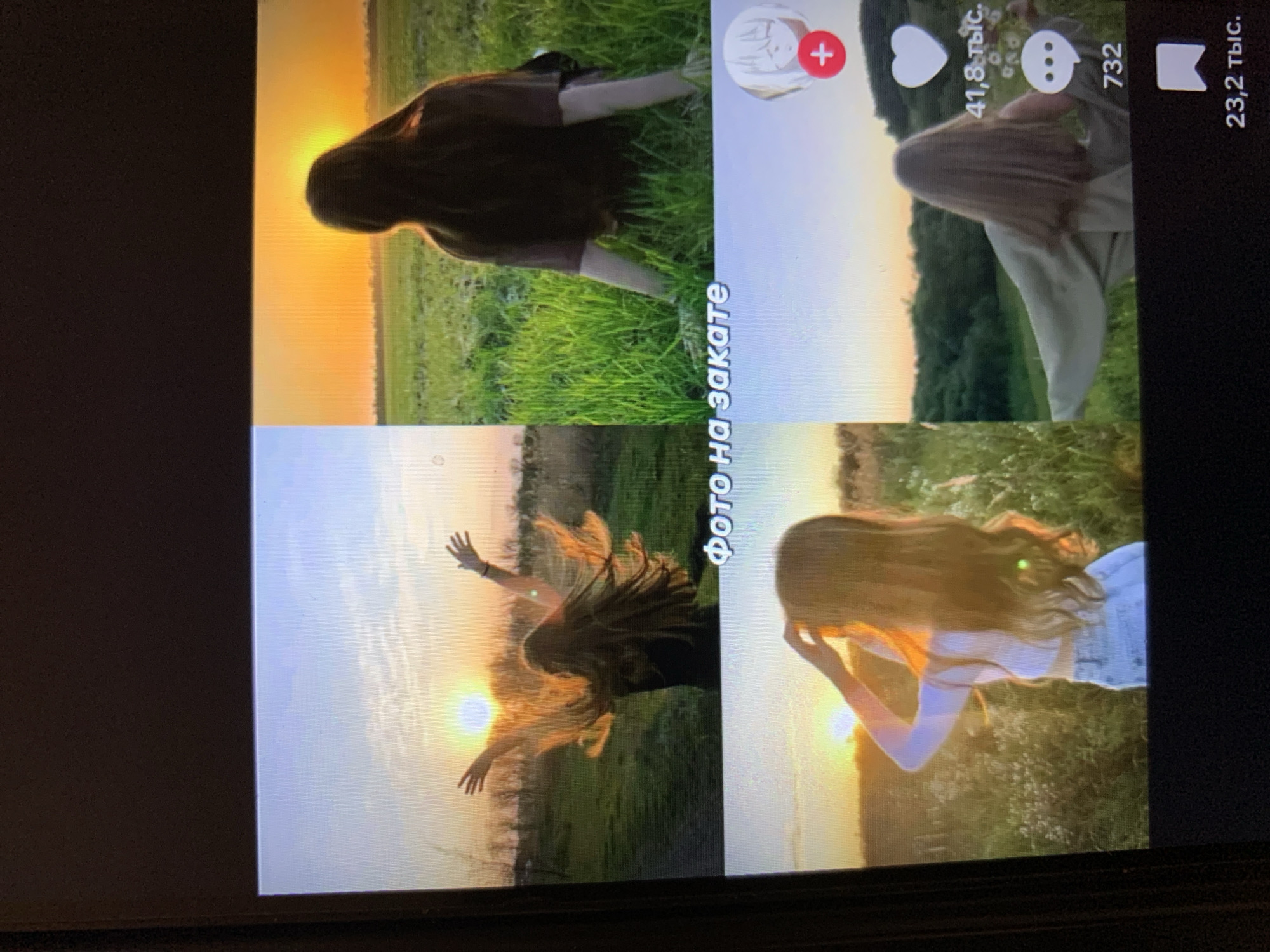 The image displays a four-panel collage of videos or photographs, likely from a social media platform, featuring young women in outdoor settings during sunset. The top left panel shows a woman with long, flowing hair with her arms outstretched towards the setting sun, which is visible in the upper portion of the frame. The top right panel depicts a woman from behind, seated in a grassy field with the sun setting in the background. The bottom left panel shows a woman from behind, with her hands touching her hair, also in a field at sunset. The bottom right panel displays a woman with her arms spread out, facing away from the camera, in a natural landscape as the sun sets. Overlaying the images are icons and text typical of social media platforms, including a red plus sign with a circle, a white heart, speech bubble icon, and numerical counts, along with the Russian text "Фото на закате" (Photo at sunset). The overall scene suggests a collection of aesthetic outdoor portraits taken during twilight. There is no discernible information within the image that connects it to the city of Lymanka, Ukraine.