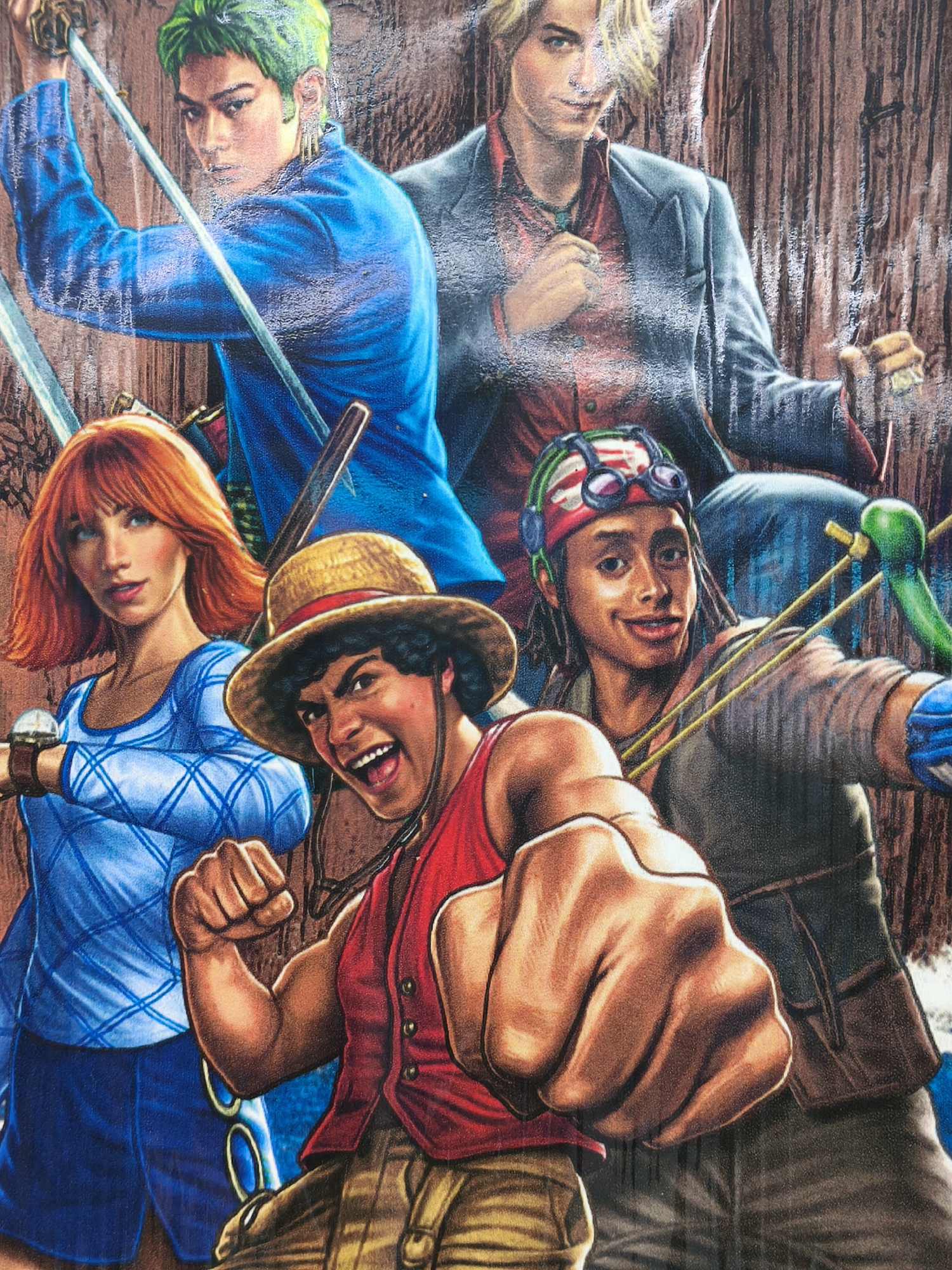 This image depicts a group of five individuals, likely characters from an anime or manga series, rendered in a colorful, textured artistic style. The characters are arranged in a close-up composition, with a focus on their faces and upper bodies.
From left to right:
The leftmost figure has short, spiky green hair and is wearing a vibrant blue, textured long-sleeved garment. They are holding a silver sword, pointing upwards and to the right. Their gaze is direct and serious.
Next to them is a woman with short, reddish-orange hair and fair skin. She is wearing a blue garment with a diamond pattern. She is looking towards the viewer with a slight smile. She appears to be wearing a watch on her left wrist.
In the center, a young man wearing a straw hat and a red sleeveless vest over a darker shirt is prominently featured. He has dark, curly hair and an excited expression, with his mouth open and a fist extended towards the viewer. He is wearing brown pants.
To the right of the man with the straw hat is a figure with dark skin, wearing a red bandana with green and white stripes and goggles pushed up on their forehead. They have dark, braided hair and are smiling. They are wearing a greenish-blue glove on their right hand and are holding what appears to be a slingshot with a green projectile. Their clothing consists of a brown, textured shirt and blue sleeves.
The background is a textured, mottled brown, resembling wood grain or a rough wall. The overall impression is one of action and camaraderie, with the characters appearing to be in a dynamic pose. The lighting is somewhat diffused, highlighting the details of the artwork.
The image is a close-up artistic depiction of characters and does not contain any elements that would place it specifically in the city of Kuta Selatan, Indonesia, or any other real-world geographical location.