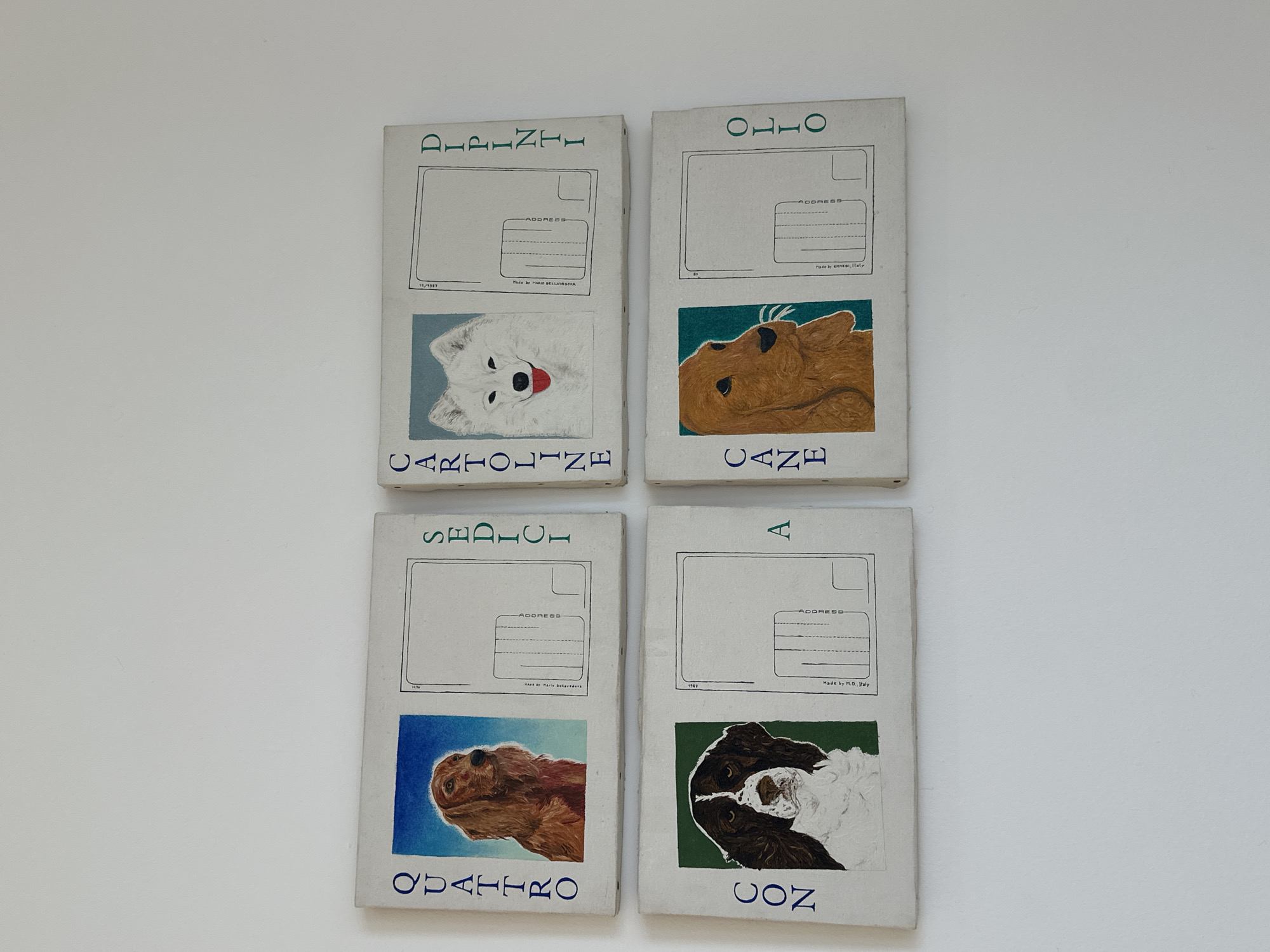 Four postcards, arranged in a two-by-two grid, are displayed against a plain white background. Each postcard features a white border, a rectangular area for an address, and a depiction of a dog breed below. The text "DIPINTI", "OLIO", "SEDICI", and "CON" are arranged vertically on the left side of each card, while "CARTOLINE", "CANE", "QUATTRO", and "A" are on the bottom, respectively. The bottom left card reads "Made By Mario Dellavesova". The bottom right card reads "Made by M.D., Italy". The top right card reads "Made by amnesi, Italy".
The location of the scene is not determinable, however, the cards indicate that the images were made in Italy.