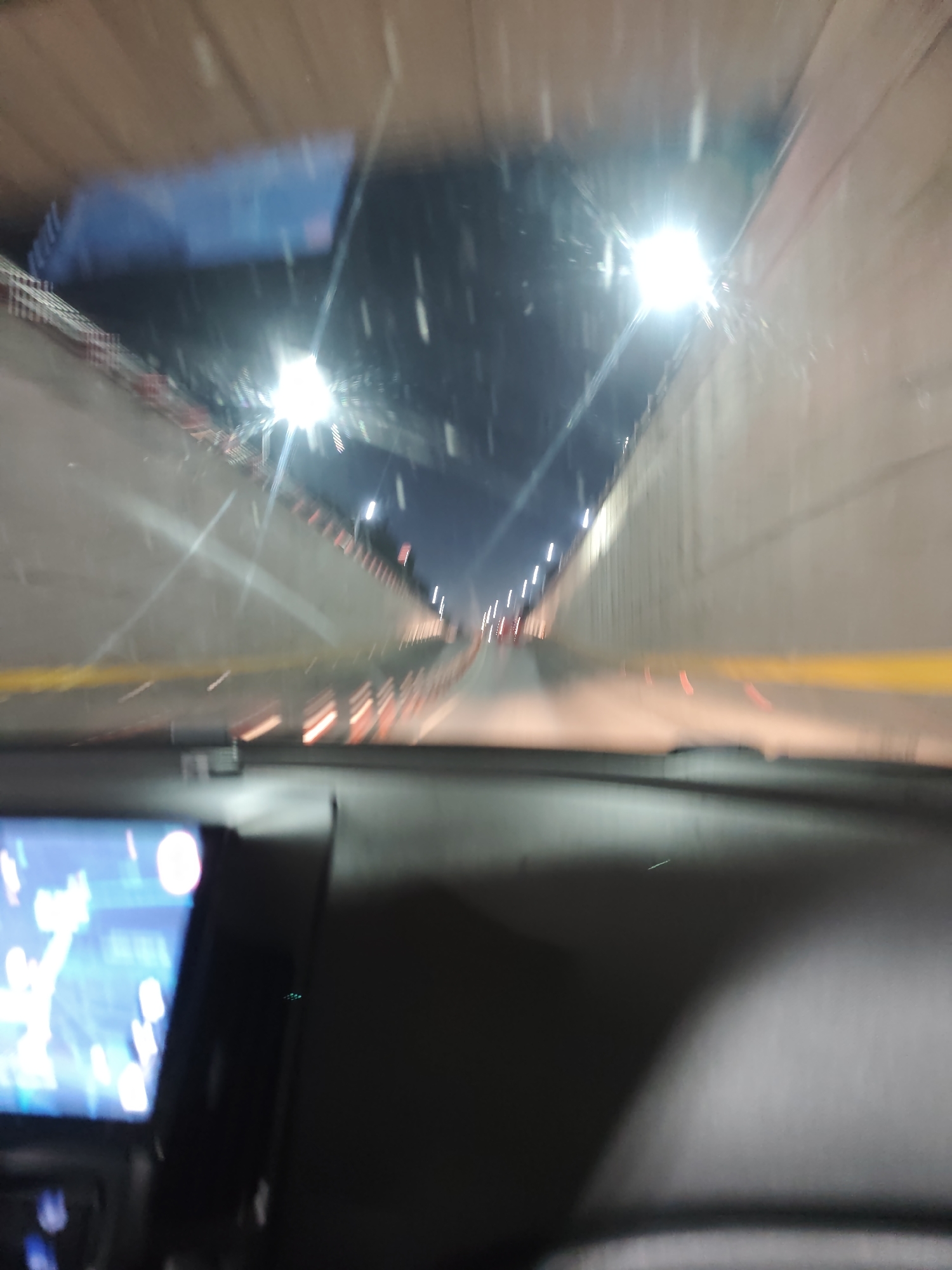 The image shows a blurry, possibly motion-blurred, interior view from inside a car driving through a tunnel. The tunnel has concrete walls and overhead lights. The car's dashboard is visible in the foreground, with a navigation screen illuminated. The location is likely Sofia, Bulgaria. The image lacks discernible details about people or specific actions.