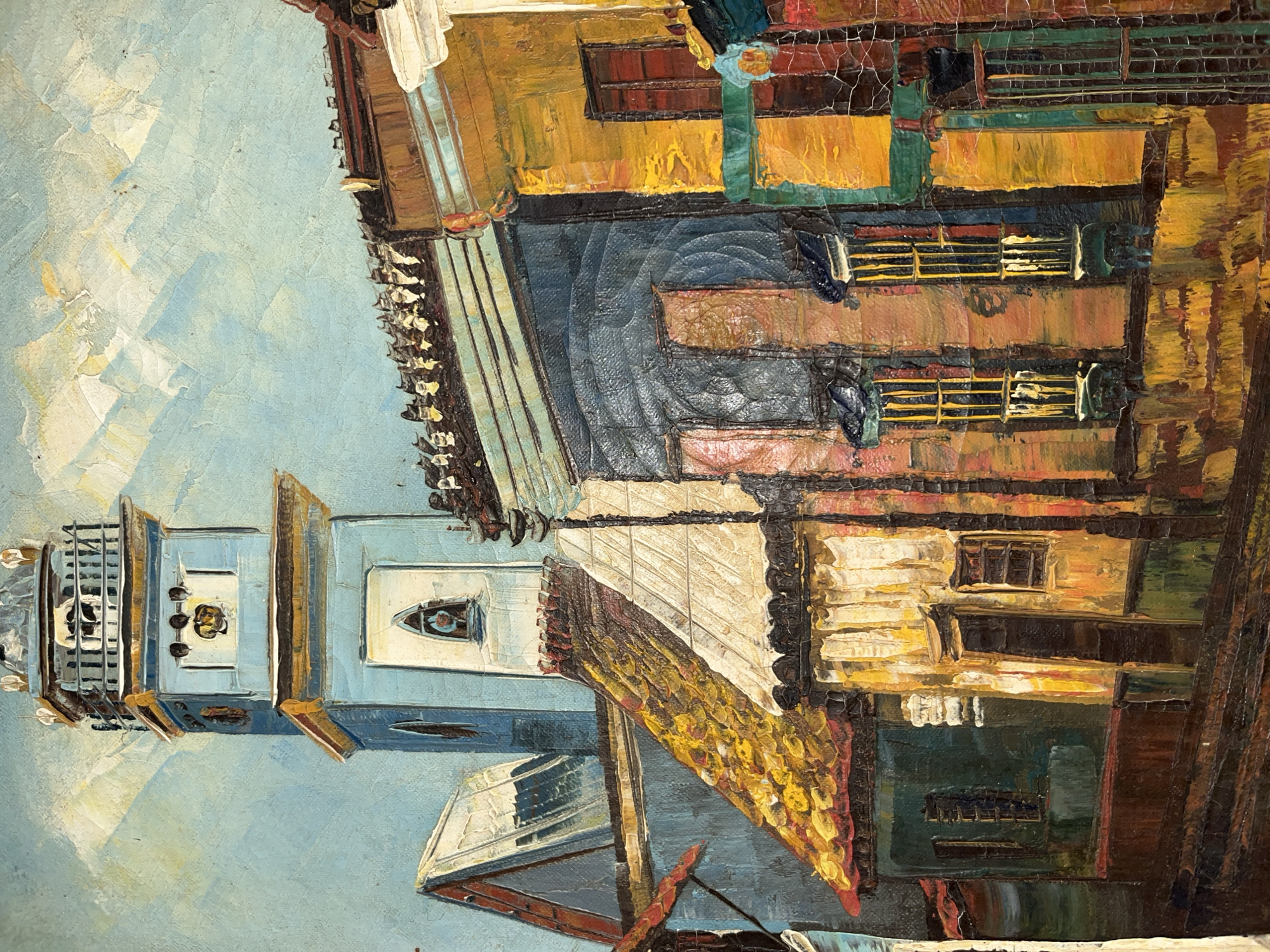 This is a painting depicting a street scene in Tinaquillo, Venezuela. The style is reminiscent of impressionism, with thick, visible brushstrokes and vibrant colors. The composition focuses on the architecture of the city, with buildings depicted in shades of yellow, brown, and blue. A prominent bell tower is visible on the left side of the painting, standing out against a blue sky. The buildings appear densely packed together, and the streets are narrow. The overall mood of the painting is lively and energetic, capturing the essence of a bustling urban environment in Tinaquillo.