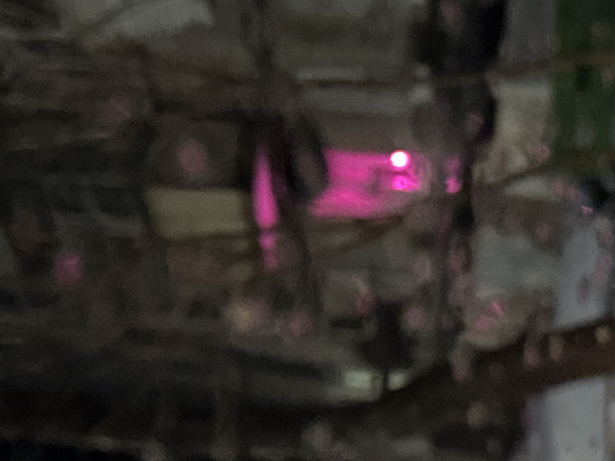 The image is highly blurred, making detailed analysis difficult. However, the presence of pink lights suggests an indoor setting with artificial lighting. Further identification of specific objects, actions, or the exact location in Chaikovsky, Russia, is not possible due to the image's low clarity.