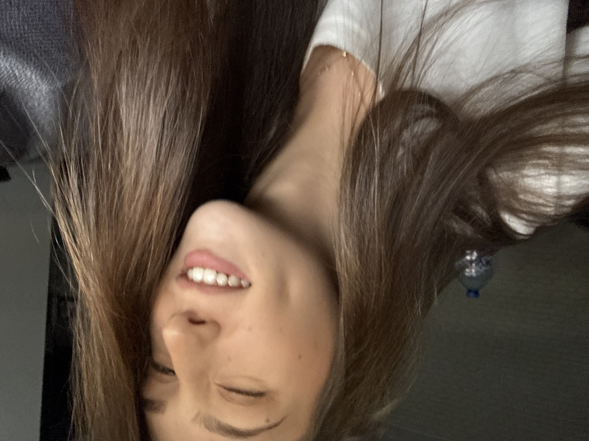 A fair-skinned woman with long brown hair is smiling. She is wearing a white top. An earring is visible. A water bottle is visible. There is no information to determine the location of the city of Sofia, Bulgaria.