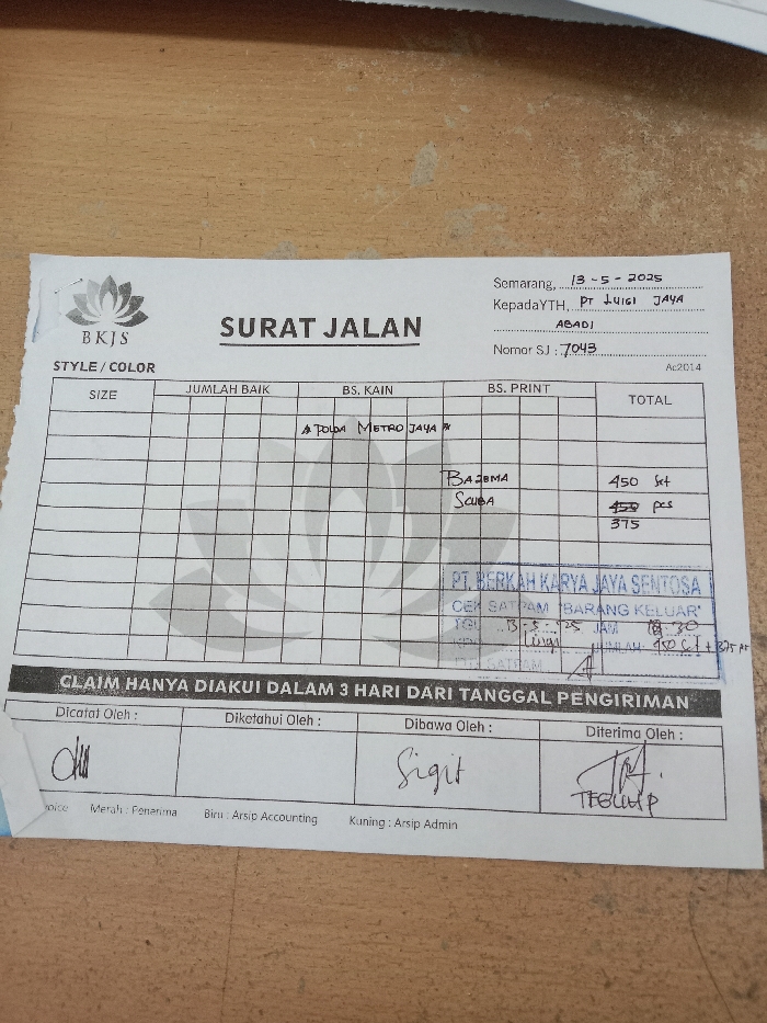 The image shows a document titled "Surat Jalan" (Waybill) from a company called "BKJS" in Semarang, Indonesia. The document is dated 13-5-2025 and addressed to PT Luig Jaya Abadi. The document number is SJ. 7043. The document is a waybill for the delivery of goods. It lists a variety of fabric styles, sizes, quantities and the total cost for each item. The waybill lists 450 "set" of "Bazima" fabric and 450 "pcs" of "Scuba" fabric. The total cost for both is 375. The document includes a signature from the "Dicatat Oleh" (Recorded By), "Diketdhui Oleh" (Approved By), "Dibawa Oleh" (Delivered By), and "Diterima Oleh" (Received By). The image was taken in the city of Kecamatan Ngaliyan, Indonesia, which is located at the coordinates -7.01 latitude and 110.364 longitude.