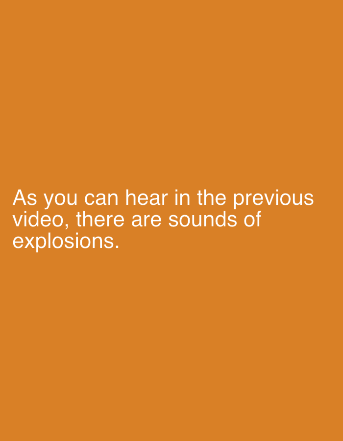 The image displays white sans-serif text against a solid, uniform orange background. The text, positioned in the lower half of the frame, reads: "As you can hear in the previous video, there are sounds of explosions." No visual scene, individuals, subjects, objects, actions, interactions, or specific environmental details are depicted within this image. The image functions as a textual informational overlay. The provided context for the sounds of explosions referenced in the text is the city of Khan Yunis, Palestinian Territory.