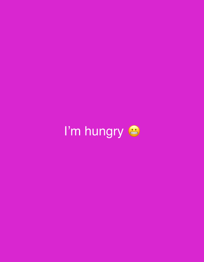 The image is a bright purple background with the words "I'm hungry" written in white text. To the right of the text is a yellow emoji with wide eyes and its mouth open, showing teeth, conveying a feeling of hunger or surprise. The text and emoji are centered vertically and horizontally on the screen. There are no visible people, specific objects or environmental details related to Vratsa, Bulgaria in this image.