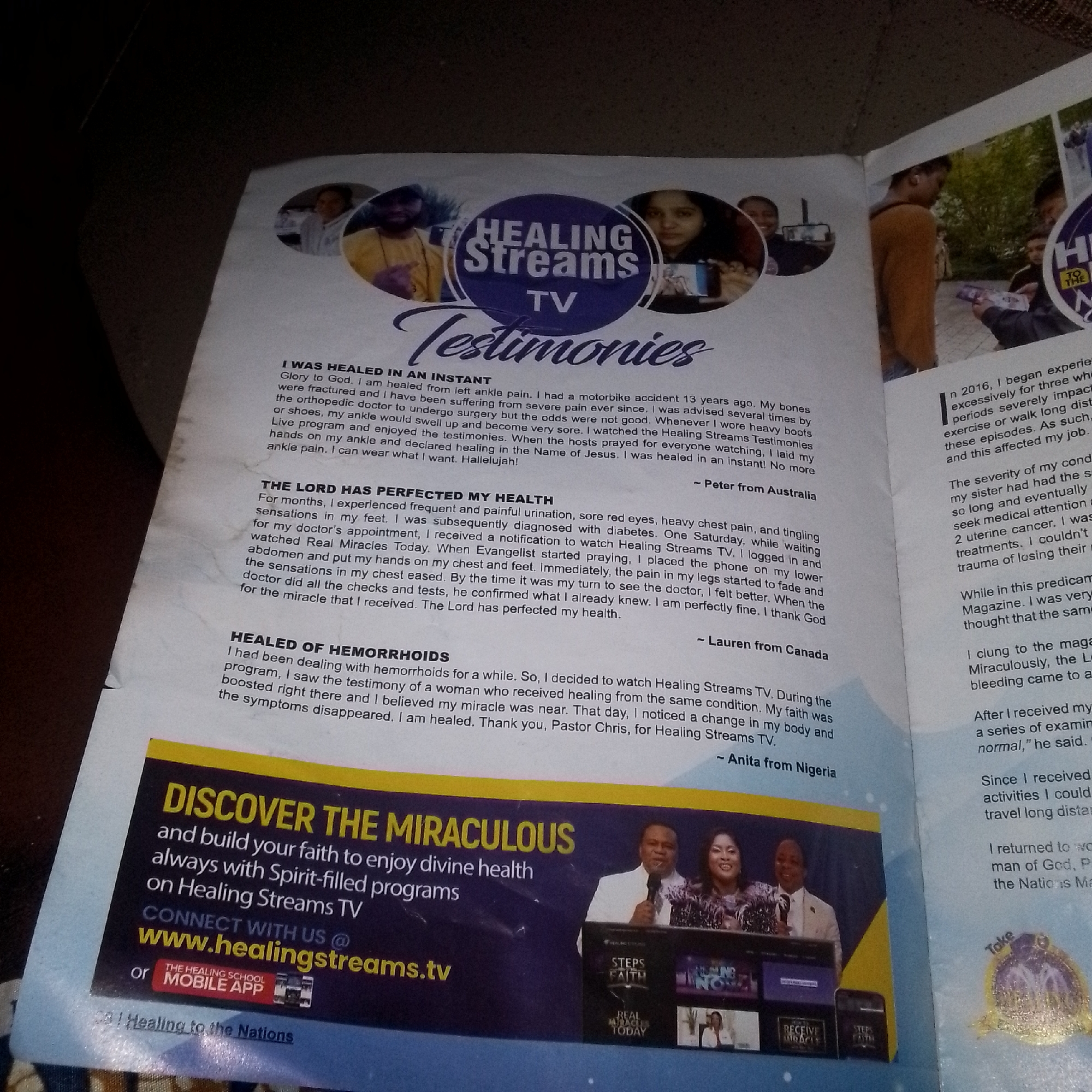 This image is a photograph of a magazine spread featuring testimonies of healing from "Healing Streams TV." The spread includes a large title "Testimonies" with accompanying photos of individuals.
On the left side, there are three written testimonies. The first, titled "I WAS HEALED IN AN INSTANT," describes a healing from left ankle pain after a motorbike accident. The second, "THE LORD HAS PERFECTED MY HEALTH," details overcoming diabetes and other health issues. The third, "HEALED OF HEMORRHOIDS," recounts a miraculous recovery. Each testimony is attributed to a person and their location, such as "Peter from Australia," "Lauren from Canada," and "Anita from Nigeria." Below these testimonies, there is a prominent advertisement for "Healing Streams TV" with the call to action "DISCOVER THE MIRACULOUS and build your faith to enjoy divine health always with Spirit-filled programs on Healing Streams TV." It also provides website and app information.
On the right side of the magazine spread, there are more testimonies with accompanying images. One testimony begins with "In 2016, I began experiencing..." and another mentions "While in this predicament...". There are also images of people, some appearing to be participants or hosts of a television program, and possibly printed materials related to the broadcast.
The image is taken from a slightly elevated angle, showing a portion of the magazine laid open. The lighting suggests an indoor setting. There is no specific visual information within the image that indicates the location as Jalingo, Nigeria. The mention of "Anita from Nigeria" is text within the magazine content, not a visual representation of the city itself.