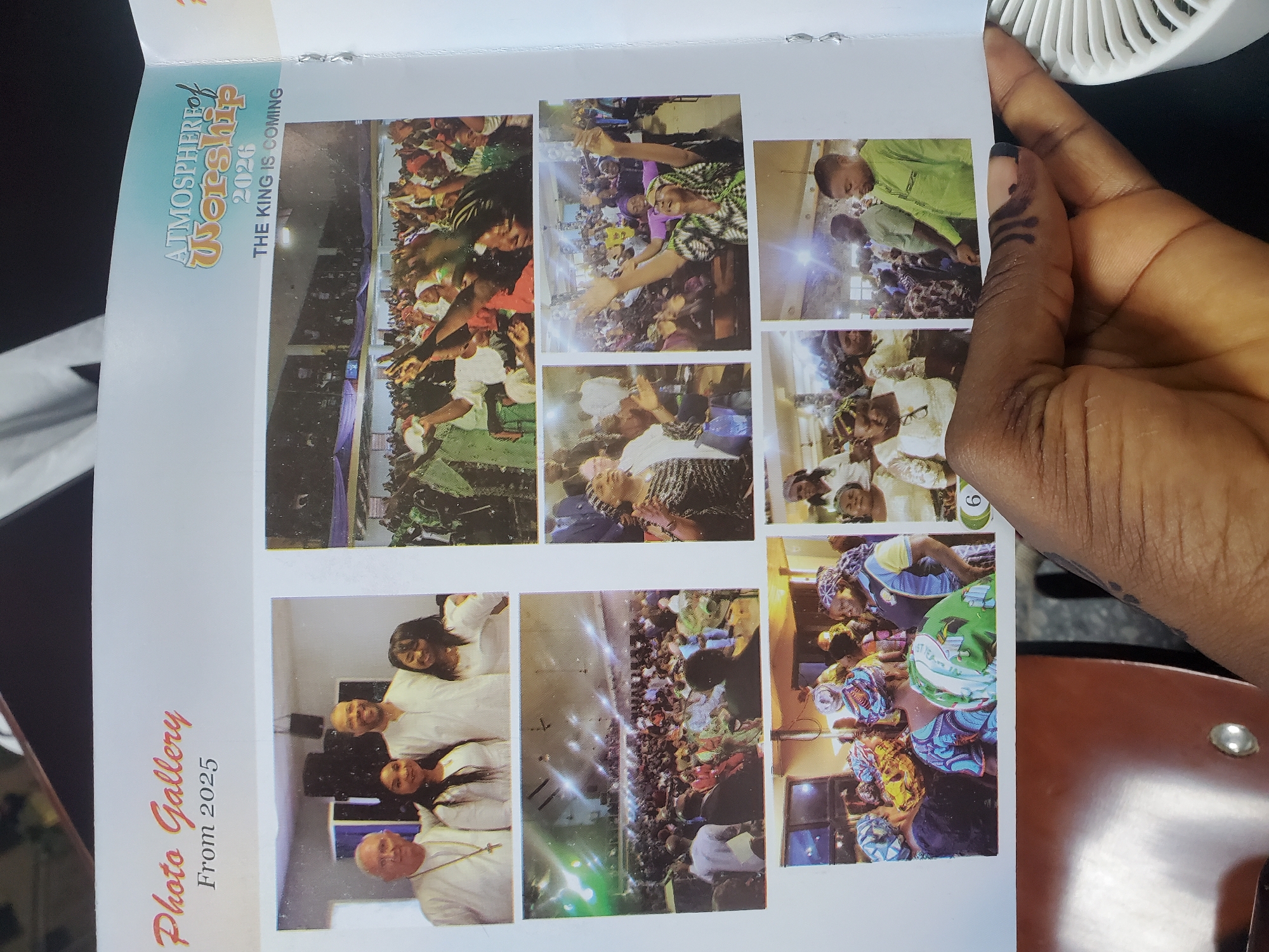 The image displays a collage of photographs on a page with text. The title "ATMOSPHERE of WORSHIP 2020 THE KING IS COMING" is visible on the left side of the page, above a row of images. Below this, "Photo Gallery From 2025" is also visible.
The photographs depict scenes of a large gathering of people, likely at a religious event given the "Atmosphere of Worship" text. Many individuals are seen with their hands raised, suggesting a moment of praise or prayer. The people are diverse in age and attire, with some wearing traditional Nigerian clothing and headwraps.
Several individual photos show close-ups of people in the crowd. One image shows a woman in a green and white patterned outfit with her arms outstretched, smiling. Another photo features a group of people in white attire, possibly clergy or attendees in uniform. A few other images capture smaller groups or individuals within the larger congregation.
The setting appears to be indoors, with a stage or raised platform visible in some of the wider shots, illuminated by stage lighting. The overall mood conveyed by the images is one of communal worship and spiritual engagement. The text "Kason, Nigeria" indicates the geographical context of these events. The presence of a hand obscuring part of the right side of the collage is a notable detail in the original image.
