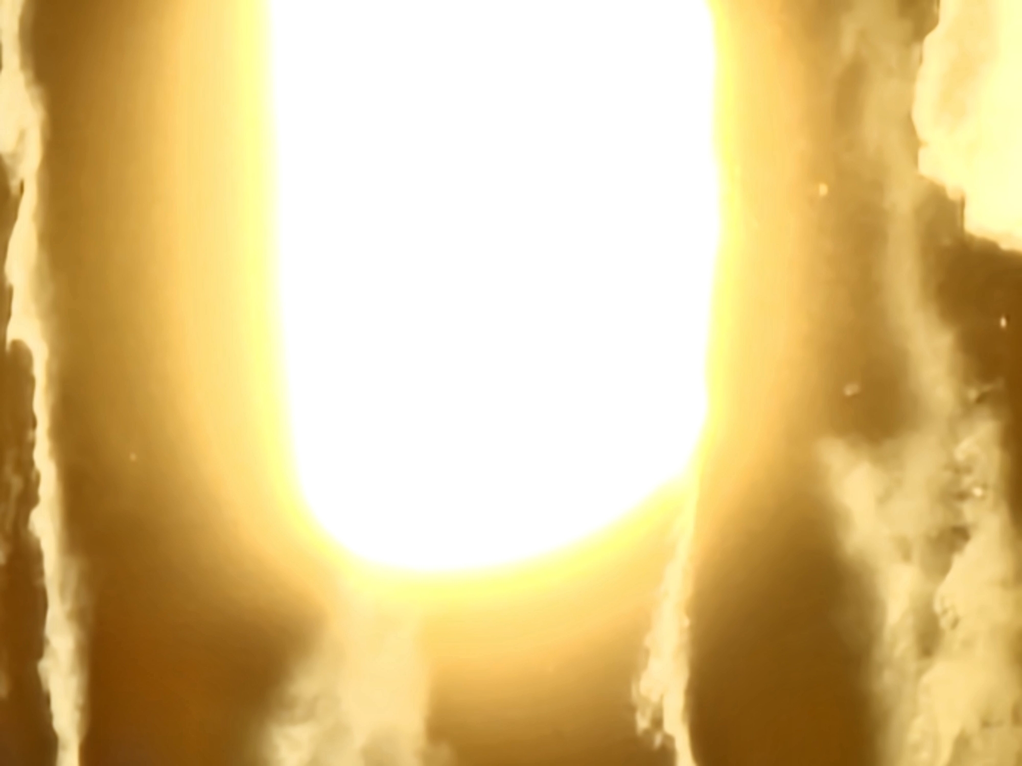 The image shows a bright, ethereal light, possibly representing the sun or a celestial event, emerging from behind dense, golden clouds. The light is so intense that it creates a halo effect and obscures any details within its immediate vicinity. The clouds are textured and appear to be swirling, with varying shades of gold and yellow, suggesting a dramatic or atmospheric sky. There are no discernible objects, people, or actions within the frame; the focus is entirely on the intense light and the surrounding cloud formations. The image does not contain any visual information that can be used to identify a specific location in the city of Khimki, Russia.