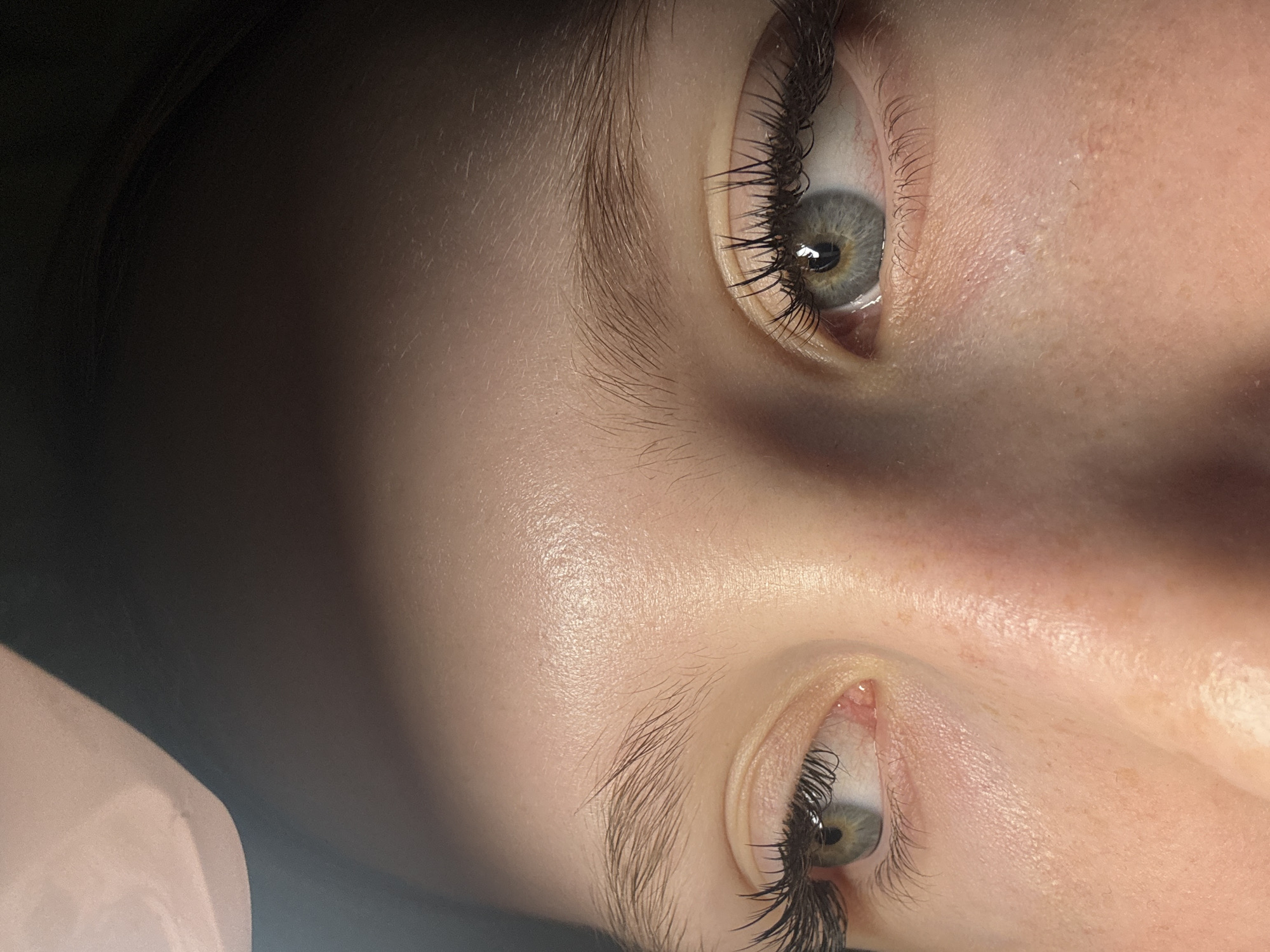 A close-up image displays a face with grey eyes and long eyelashes. The skin has a light complexion and a slightly shiny appearance. The image is rotated and cropped, focusing on the eyes and surrounding facial features. There is no evidence suggesting the location is Chaikovsky, Russia.