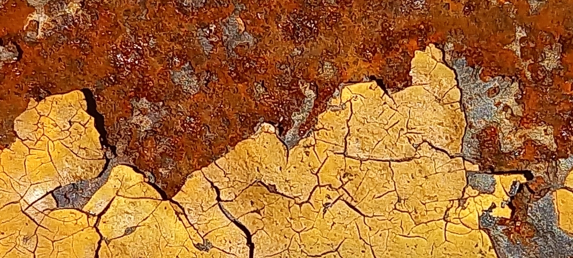 The image is a close-up of severely weathered and corroded metal. The dominant features are flaking and cracked yellow paint overlaying rust. The rust appears coarse and textured. The cracks in the paint reveal the metal substrate beneath, which shows both rust and possibly remnants of a prior coating. There are no people, subjects, objects, actions, interactions, or environmental clues, so the location in Kryvyi Rih, Ukraine, is unknown.