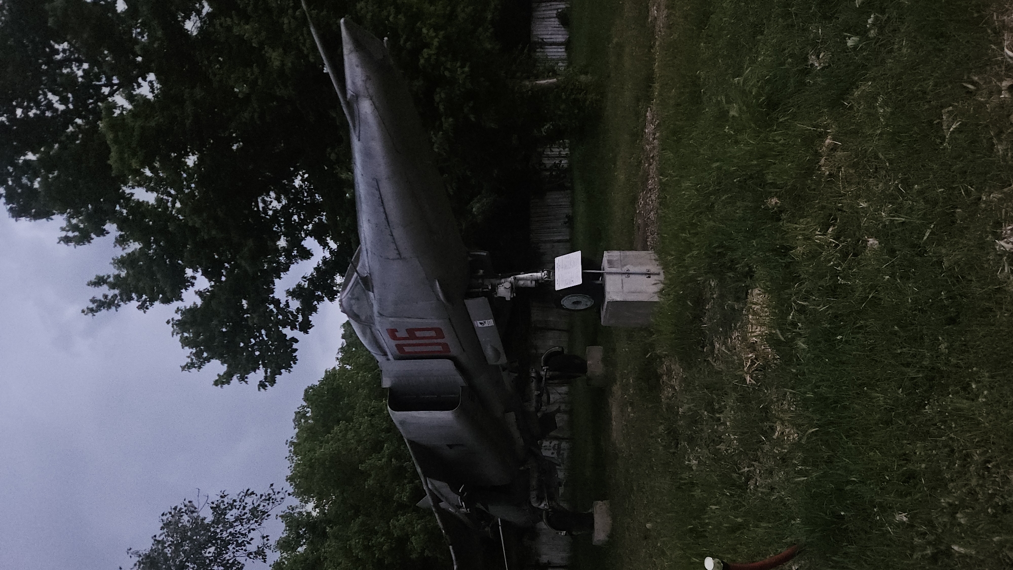 An aircraft, marked with "90", is displayed on concrete supports in an outdoor environment with grass and trees in Plovdiv, Bulgaria.