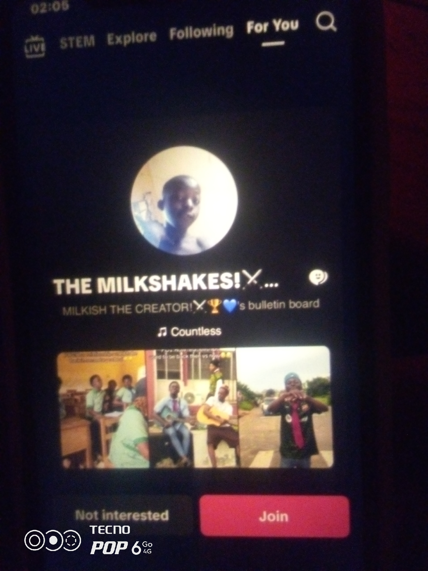The image displays a smartphone screen showing a social media profile. At the top, the time "02:05" is visible, followed by navigation options "LIVE," "STEM," "Explore," "Following," and "For You," with a search icon on the right. A circular profile picture of a young Black male is centered. Below this, the text "THE MILKSHAKES!" is prominently displayed, followed by "MILKISH THE CREATOR!" and a trophy and blue heart icon, and then "'s bulletin board." Below this, the word "Countless" is shown with a music note icon. The lower half of the screen features a grid of four images. The top left image shows a group of young Black males and females in what appears to be a classroom setting, some wearing green uniforms. The top right image shows a young Black male with a light-skinned complexion wearing a dark t-shirt and a blue cap, holding a red object and posing in front of a road. The bottom left image shows a group of people, similar to the top left image. The bottom right image shows another young Black male, appearing to be in a performance or casual setting, holding a guitar. At the very bottom of the screen, there is a "Not interested" button and a "Join" button. The phone branding "TECNO POP 6 4G" is also visible. The image context does not provide any specific information about the city of Howayi, Nigeria.