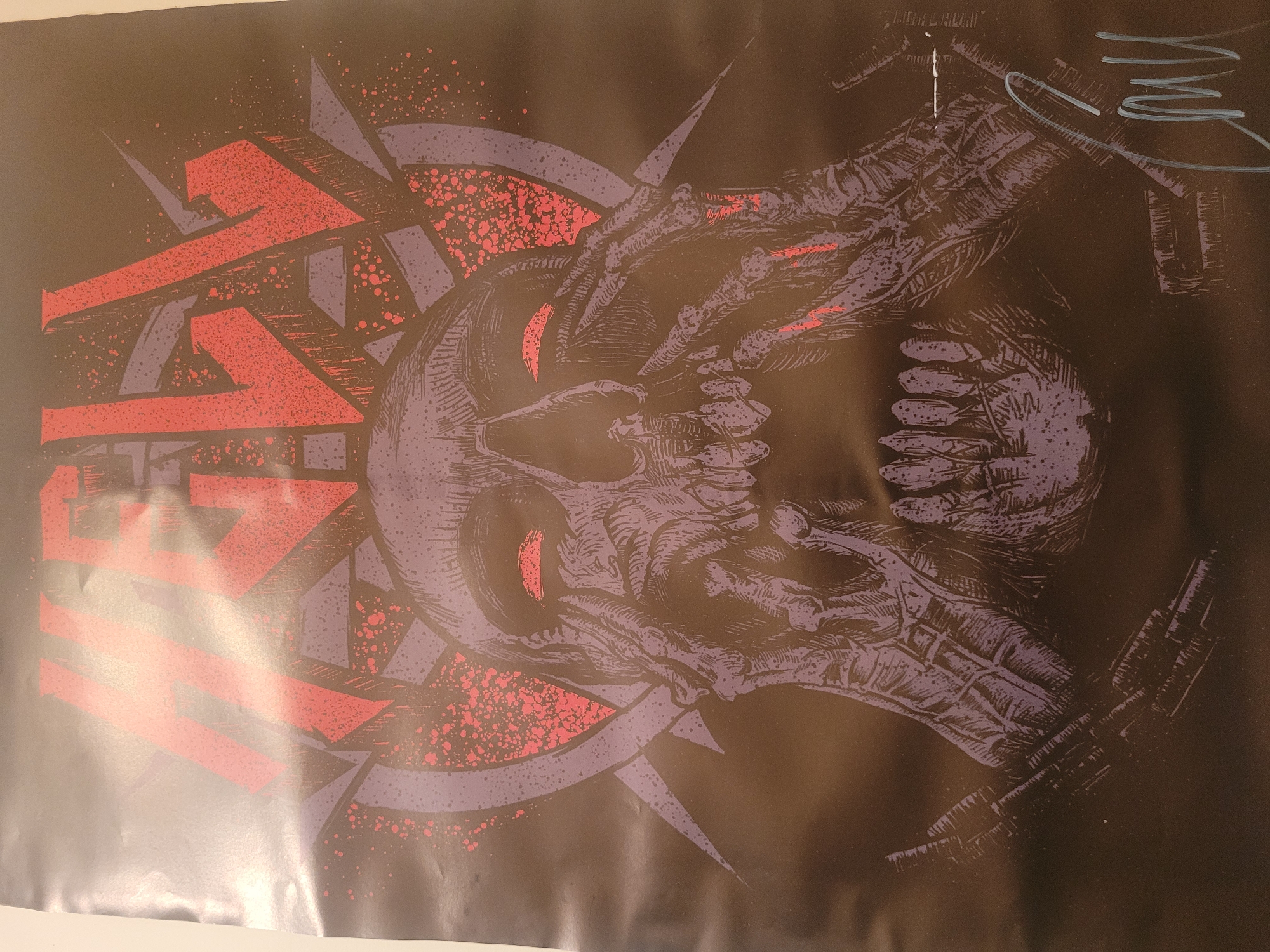 The image is a poster or print featuring a skull with glowing red eyes, partially obscured by stylized text in red and purple. The skull is rendered in a dark, textured style, with details suggesting bone and skin. Parts of the skull are interwoven with sharp, geometric shapes in purple. To the right of the skull, there are what appear to be mechanical or cybernetic hand or limb details, also in the same dark textured style. The background is black, with a splatter pattern of red and purple dots. There is a light-colored signature or marking in the upper right corner. There is no evidence or information to confirm or deny the location.