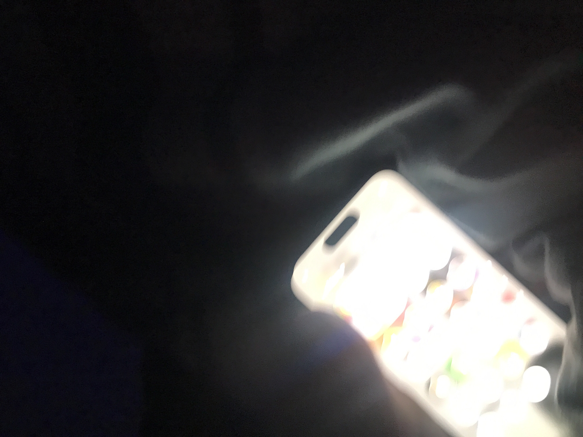 A cell phone is illuminated against a dark background. The screen of the phone is brightly lit, obscuring the details of the apps or content displayed. The phone appears to be held in someone's hand, though only a vague outline of the hand is visible. The location of Yerevan, Armenia, is not discernable from the visual elements.