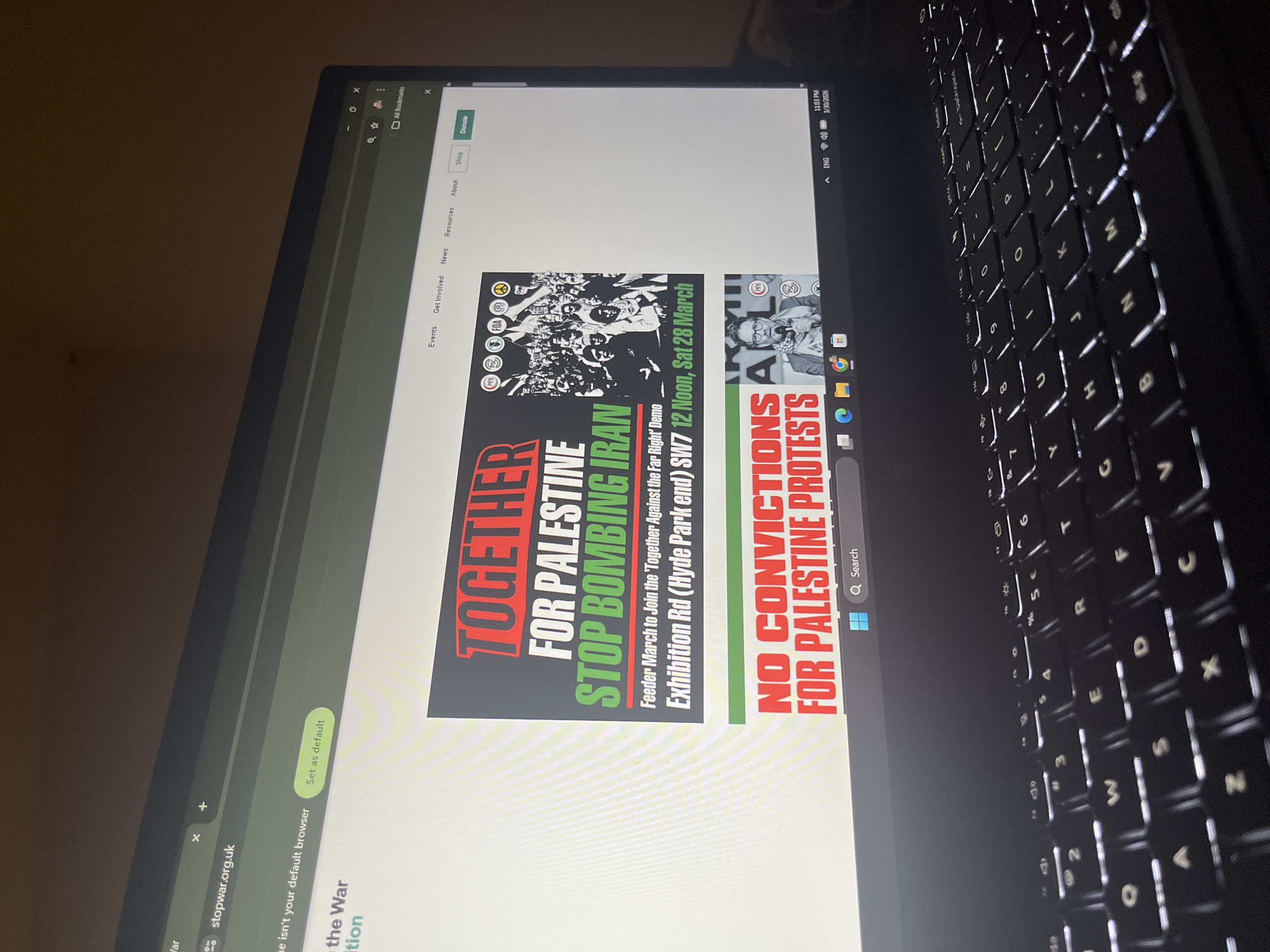 The image shows a laptop screen displaying a webpage from stopwar.org.uk. The page features posters promoting a protest: "TOGETHER FOR PALESTINE STOP BOMBING IRAN" and "NO CONVICTIONS FOR PALESTINE PROTESTS." The protest location is listed as Exhibition Rd (Hyde Park end) SW7, with a time of 12 Noon, Sat 28 March. The laptop keyboard is visible in the foreground. The location of the scene cannot be determined as Sofia, Bulgaria.