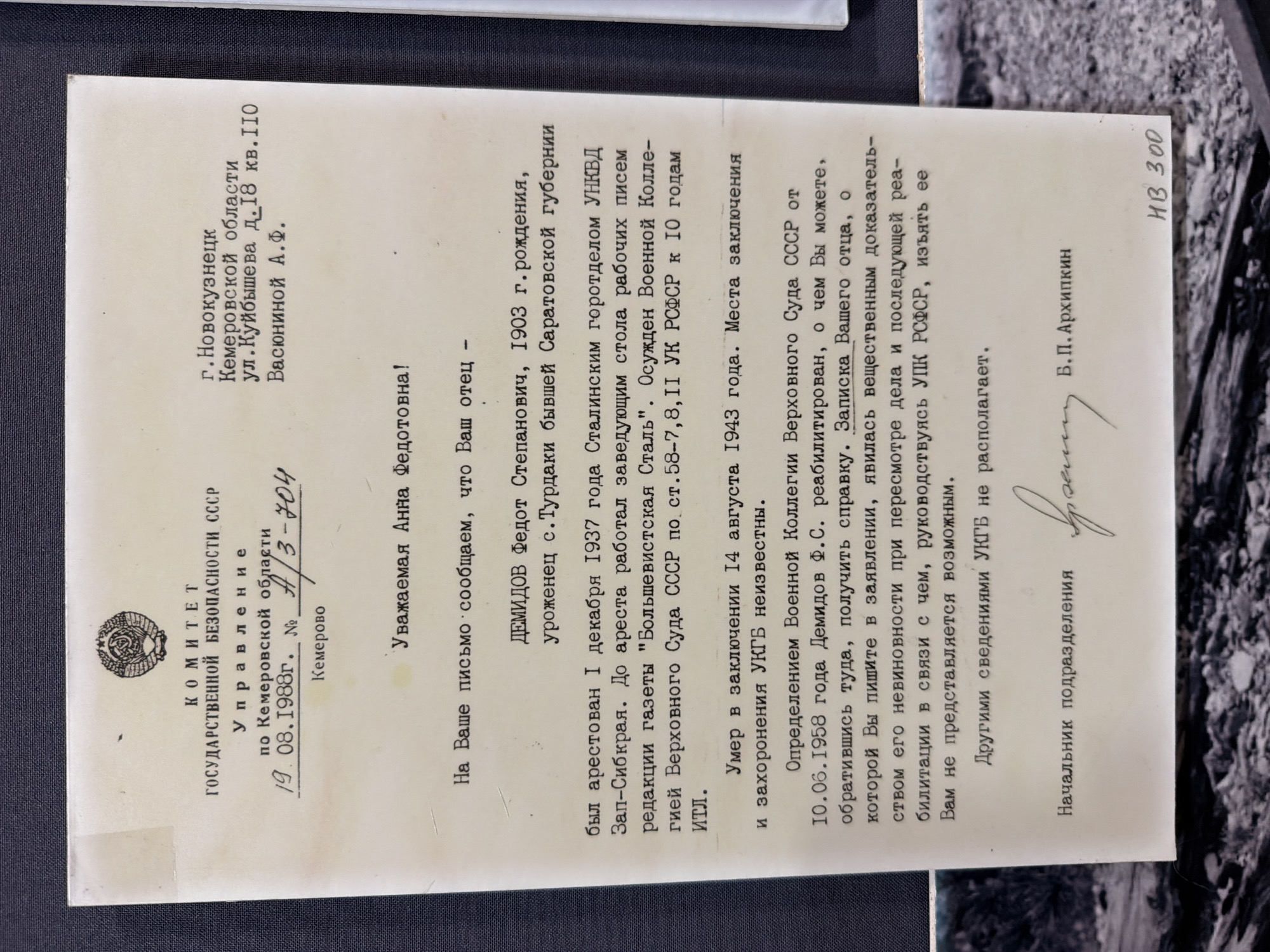 The image is a document with a letterhead from the Committee for State Security USSR, Administration for Kemerovo Oblast. The letter is dated 19.08.1988 and is addressed to "Dear Anna Fedotovna". The body of the letter discusses the arrest and fate of her father, Demidov Fedot Stepanovich, born in 1903. It states he was arrested on December 1, 1937, by the Stalin City Department of NKVD and worked as a clerk in the editorial office of the newspaper "Bol'shevistskaya Stal'". He was sentenced by the Military Collegium of the Supreme Court of the USSR to 10 years. He died in confinement on August 14, 1943, and his place of burial is unknown to the KGB. The letter further states that an official determination by the Military Collegium of the Supreme Court of the USSR on June 10, 1958, rehabilitated Demidov F.S., but obtaining a certificate and a note from his father, which is considered substantial evidence, is not possible. The document is signed by the Head of Department, B.P. Arkhipkin. The location mentioned, Ust'-Pyzas, Russia, is not explicitly present in the document itself. The bottom right corner has handwritten text "HB 300".