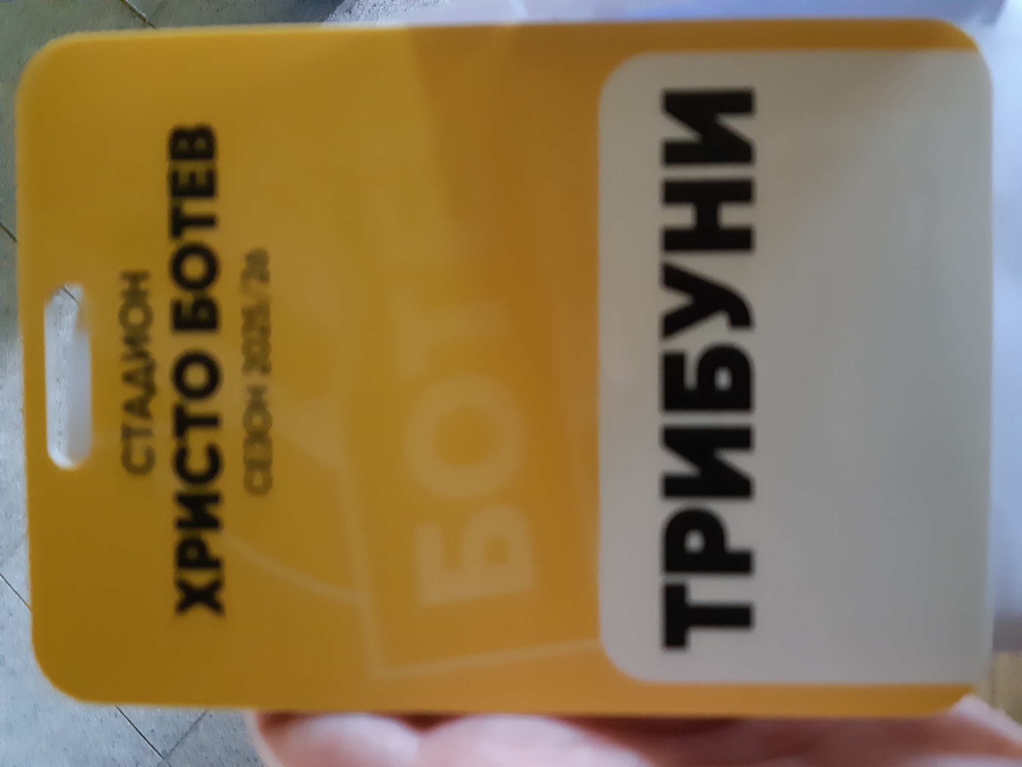 A yellow plastic card reads "Стадион Христо Ботев Сезон 2025/26 ТРИБУНИ". This suggests the card is related to the Hristo Botev Stadium located in Plovdiv, Bulgaria for the 2025/26 season, and it specifies access to the grandstands ("ТРИБУНИ"). The stadium is associated with PFC Botev Plovdiv, a football club.