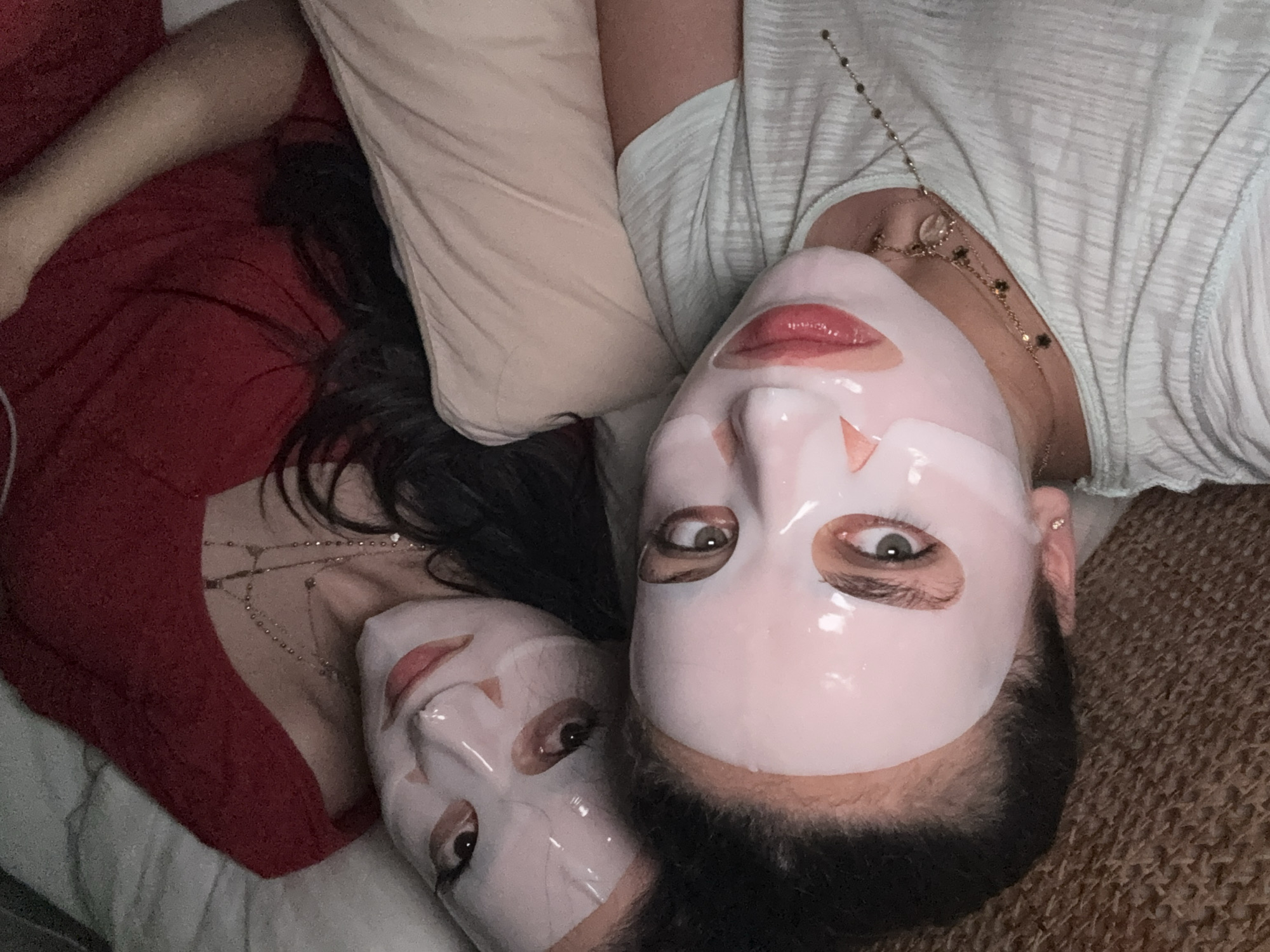 Two individuals are positioned close together, wearing sheet masks. One person is dressed in a red top while the other is wearing a white top. The location is unidentified and there is no evidence the picture was taken in the city of Yerevan, Armenia.