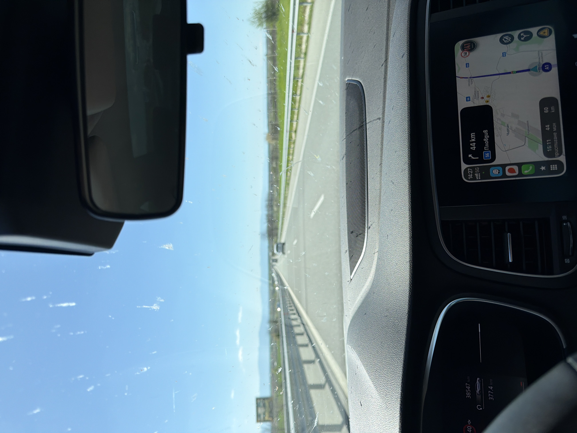 The image appears to be taken from the interior of a car traveling on a highway. The navigation system indicates the destination is "Пловдив," approximately 44 km away. The timestamp on the navigation system shows 14:27, with an estimated time of arrival at 15:11. The odometer reads 38547 km, and the fuel range is 377.4 km. The location may be near Rupkite, Bulgaria, based on the "Чирпан" displayed on the navigation system, which is a nearby city. The weather seems clear with a blue sky visible through the windshield.