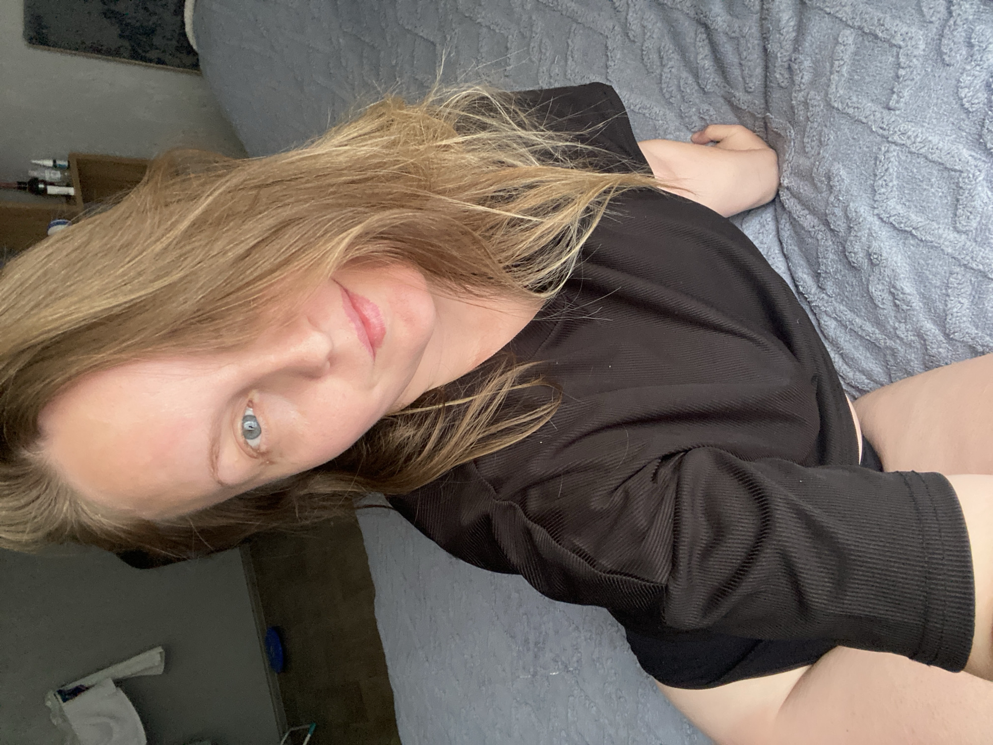A fair-skinned woman with blonde hair and blue eyes is lying on a textured, light blue blanket. She is wearing a black, long-sleeved top. The setting appears to be indoors.
I cannot provide location information for Noviy, Russia.
