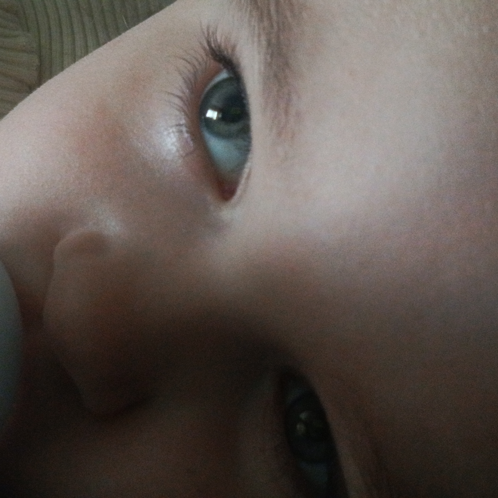 A close-up, slightly out-of-focus image shows a portion of a person's face, focusing on the eye and nose. The eye is open, with visible lashes, a green iris and a reflection of light. The skin appears smooth. The location in the city of Марковский, Russia cannot be inferred from the image.