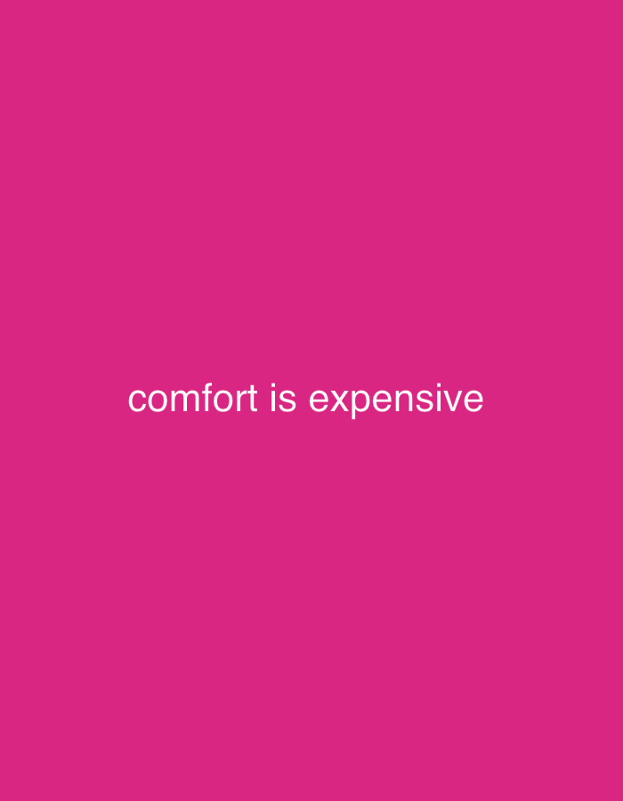 The image displays the phrase "comfort is expensive" in white text centered on a solid magenta background. There are no other discernible objects, people, or environmental details visible. The location is unknown.