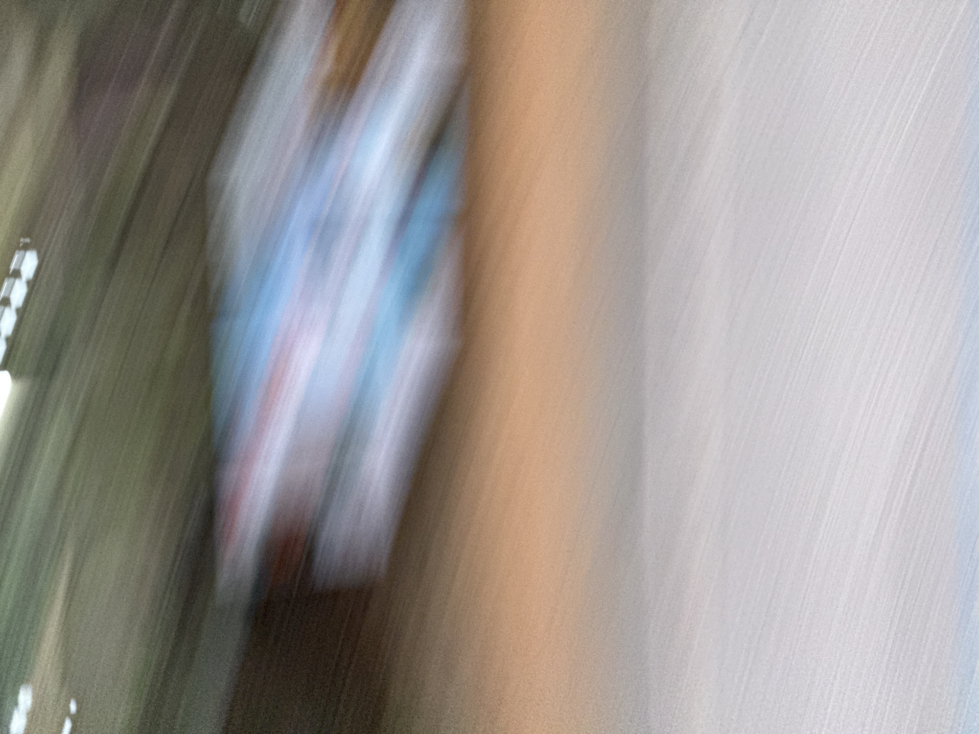 The image is blurry and indistinct, making precise identification difficult. It appears to be an image taken during motion, likely handheld. It may include a figure wearing clothing with blue and white colors. The background appears to consist of brown and white surfaces. There is no discernible information to indicate the location is Guilin, China.