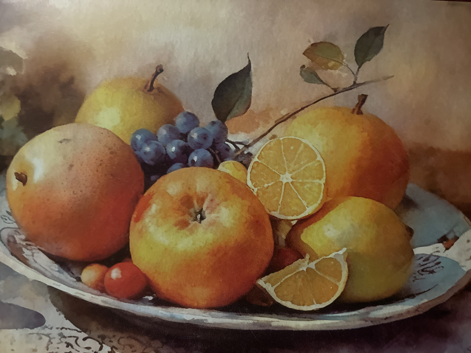 The image is a still life painting of a fruit arrangement in a bowl. The arrangement includes apples, pears, grapes, and sliced oranges or lemons. The fruits are depicted in warm, vibrant colors and appear to be ripe. The bowl itself is ornate with a light blue interior and a decorative rim. The background is softly rendered, creating a warm and inviting atmosphere. The painting style is realistic, with attention to detail in the rendering of light and shadow. The artwork is not located in the city of Minsk, Belarus.