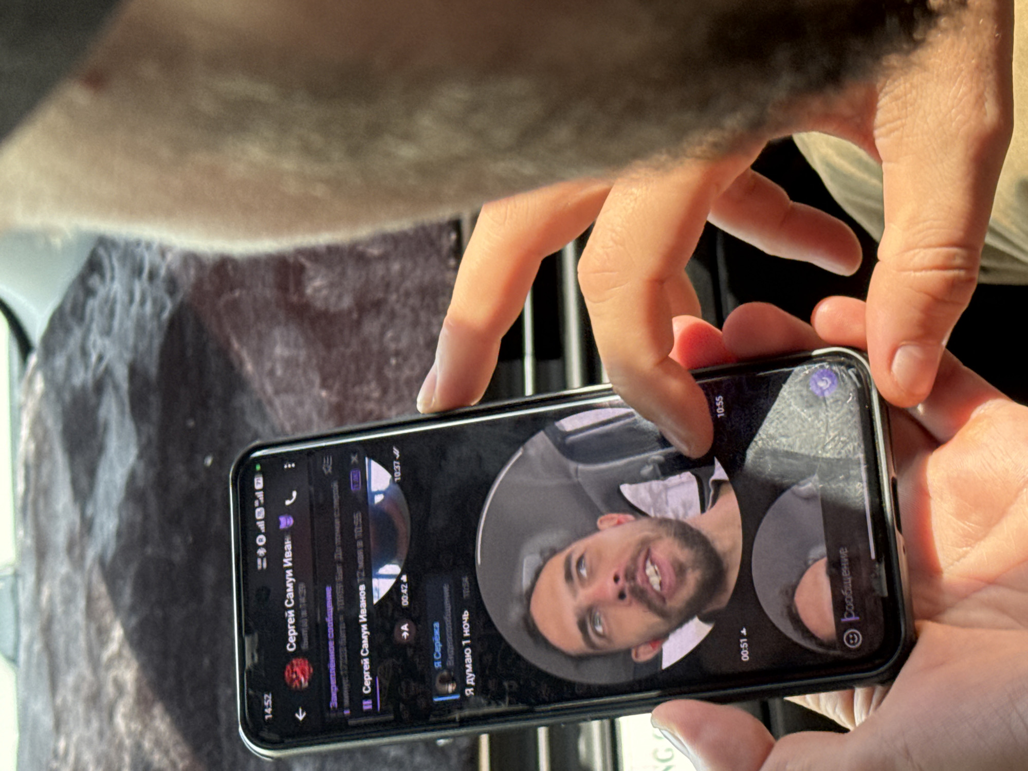 A man is holding a smartphone displaying a Telegram conversation. The screen shows the chat history with "Сергей Самуи Иван", including the user's sent message "Я думаю 1 ночь". The phone is being held indoors. No definitive signs of Ha Noi, Vietnam are visible.