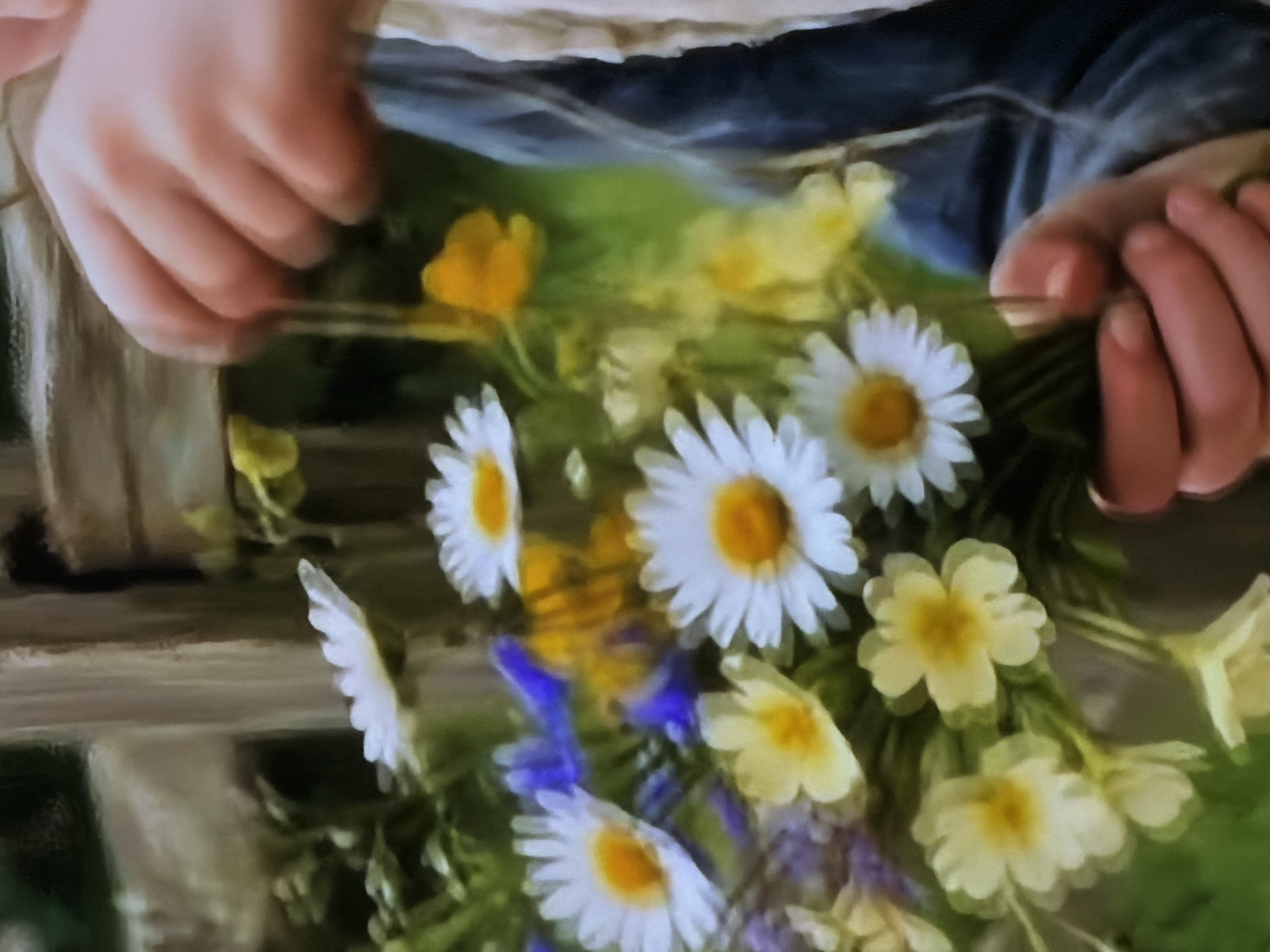 The image displays a close-up, softly focused view of a person's hands arranging a bouquet of freshly picked wildflowers. The hands, which appear relatively small and smooth, suggesting they belong to a child or young person, are positioned at the top and sides of the frame. The left hand gently grasps a collection of flower stems, while the right hand is visible on the right side, seemingly adjusting or adding more blooms to the bunch.
The bouquet is rich with a variety of wildflowers, predominantly featuring white daisies with bright yellow centers, numerous smaller yellow flowers that resemble buttercups or primroses, and scattered clusters of purple-blue wildflowers. Green foliage and stems are interwoven throughout the arrangement, enhancing its natural aesthetic.
The background is heavily blurred, creating a soft bokeh effect. It shows indistinct patches of vibrant green, likely grass or other natural ground cover, alongside darker, shadowy areas that could be distant vegetation or elements of the person's clothing. The scene conveys a sense of innocence, connection to nature, and a tranquil outdoor activity. The time of day appears to be daytime, under natural light. This activity takes place in Sofiivska Borshchahivka, Ukraine. No visible text is present in the media file.