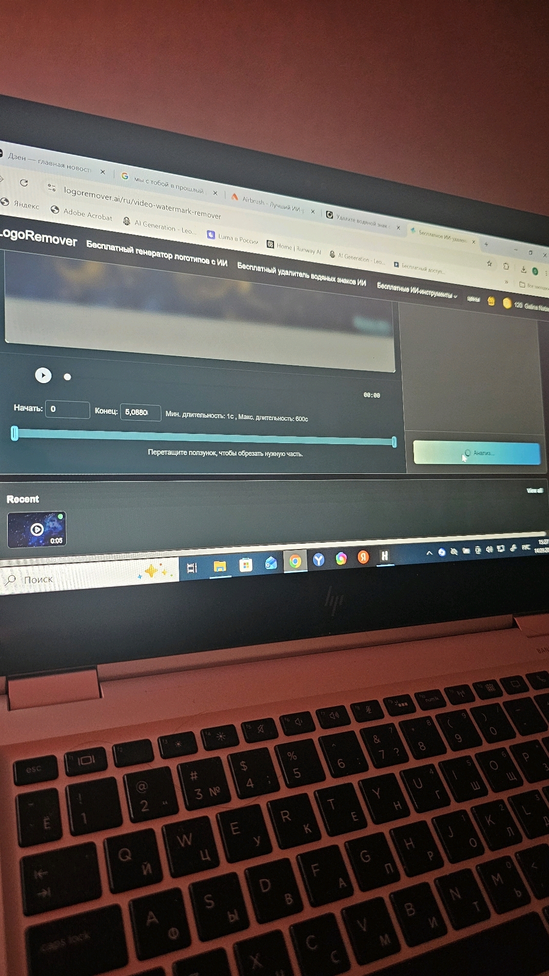 The image shows a close-up view of a laptop screen displaying a video editing or watermarking removal website. The website is identified as "LogoRemover" with the URL "logoremover.ai/ru/video-watermark-remover". The screen shows a video timeline with controls for "Начать" (Start) and "Конец" (End), with values "0" and "5.0880" respectively. There are also options for minimum and maximum duration, and a button labeled "Анализ..." (Analyze...). Below the timeline, a section labeled "Recent" displays a thumbnail of a video with "0:05" duration. The keyboard of the laptop, which appears to be a rose-gold color, is partially visible in the foreground, with Russian keyboard layout characters. The background is a plain, reddish wall. There is no indication of the location in Rostov-on-Don, Russia.